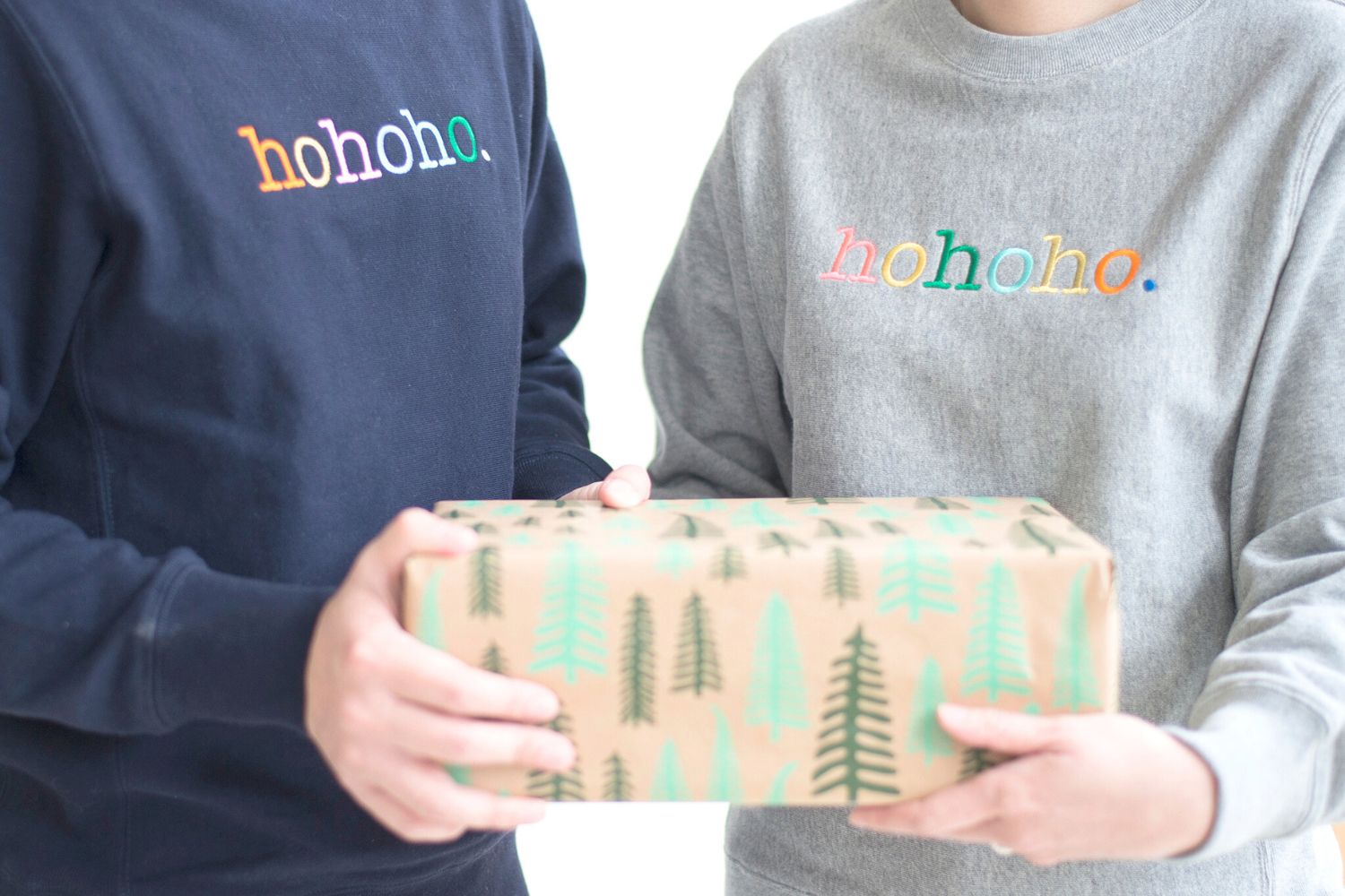 Personalized Christmas sweater worn while holding a gift