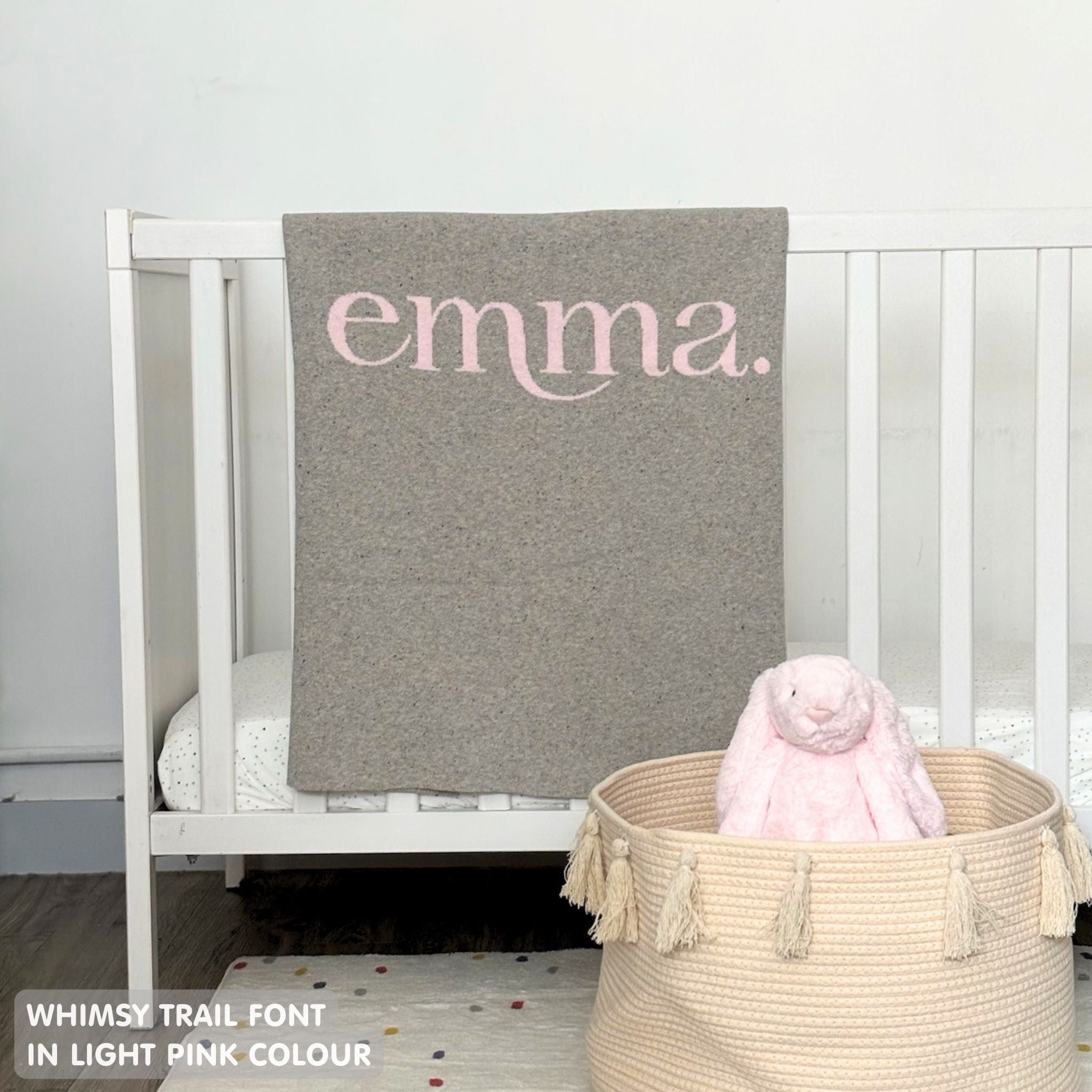 Baby blanket knitted from cotton personalized with baby's name in grey and light pink with a confetti pattern, made by TinyBitz.