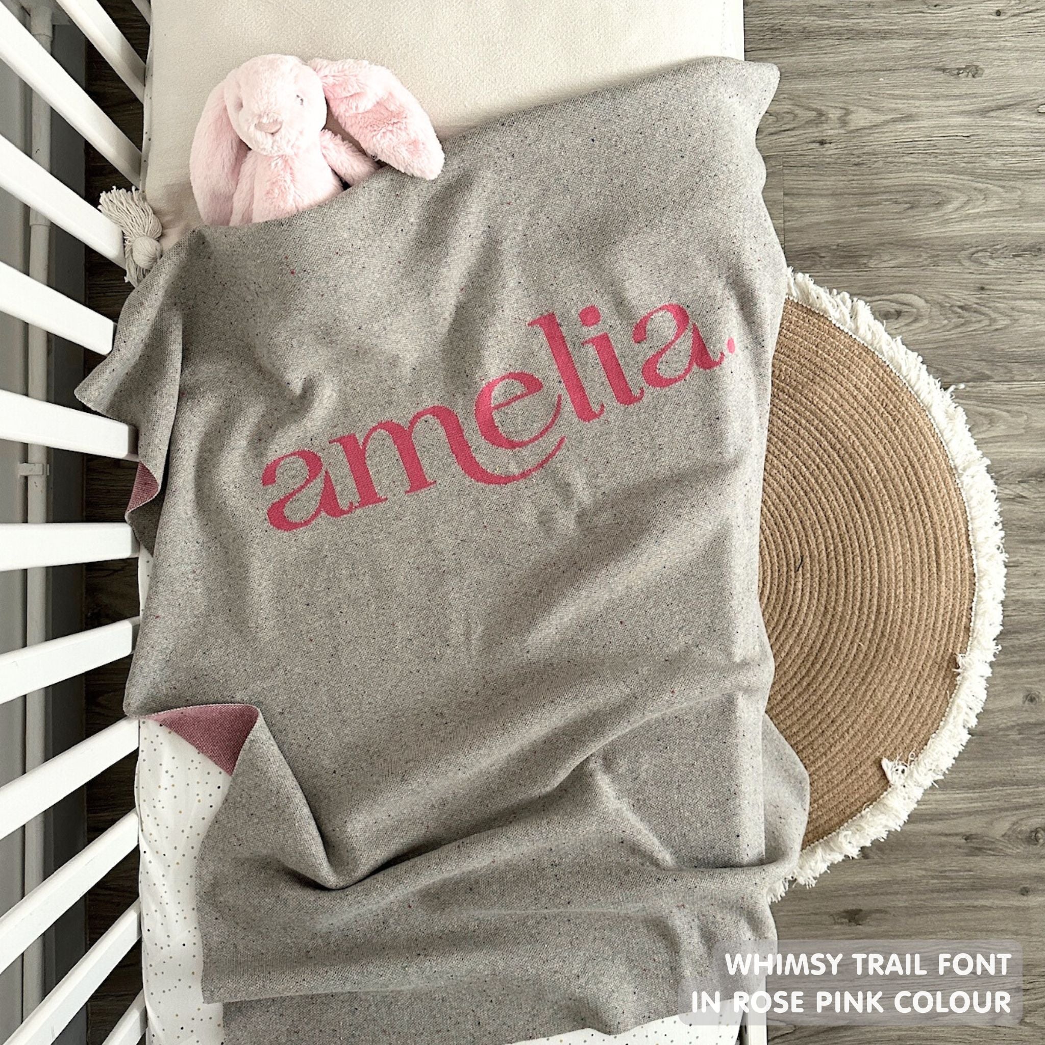 Knitted baby blanket in grey and rose pink with a confetti pattern, customised with baby's name, made by TinyBitz.
