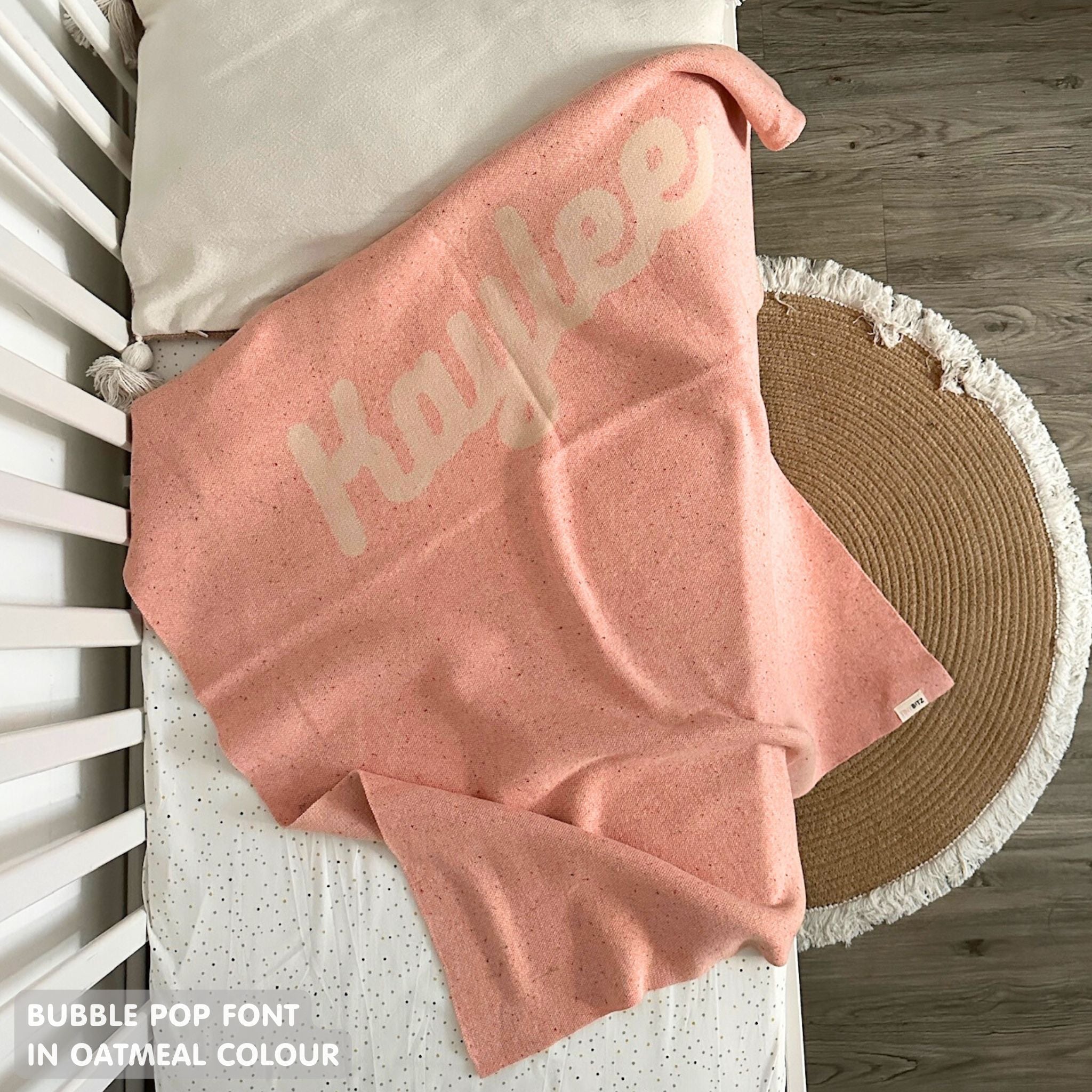 TinyBitz knitted name blanket in pink and oatmeal with a confetti pattern, a lovely touch to decorate your baby's room!
