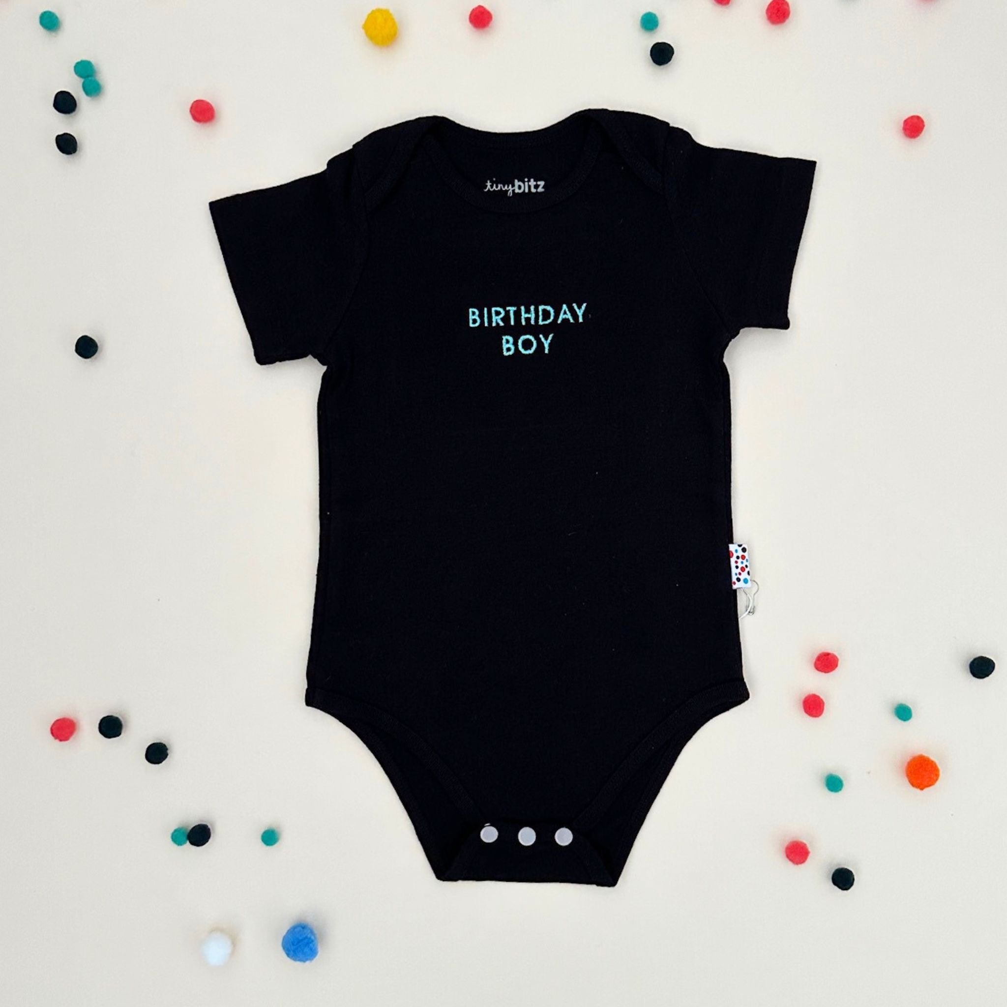 Organic cotton baby onesie with quote “Birthday Boy”, ideal for baby shower gifts and keepsakes by TinyBitz.