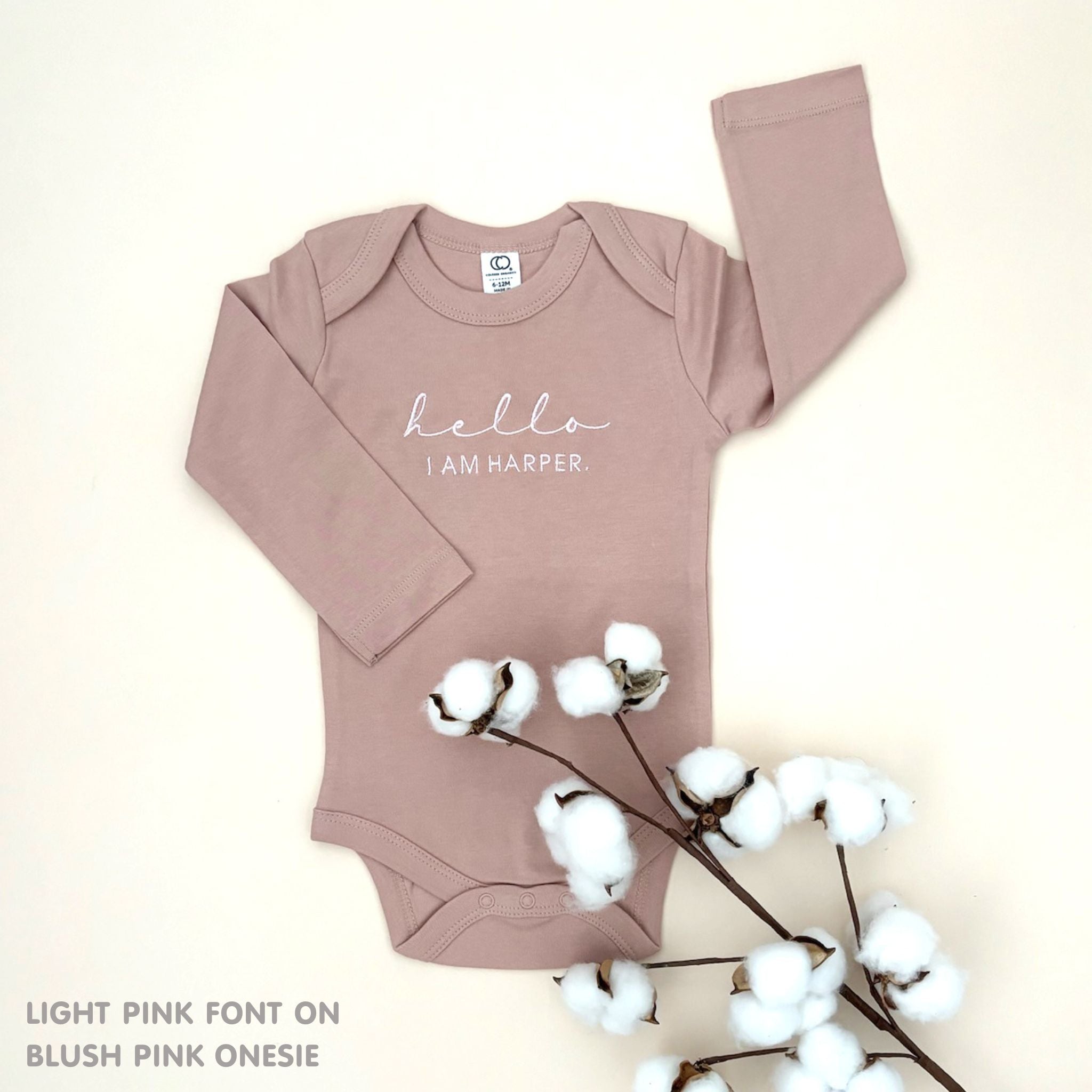 TinyBitz Personalised baby onesie with embroidered name in soft blush pink cotton, perfect for birth announcements and newborn photos.