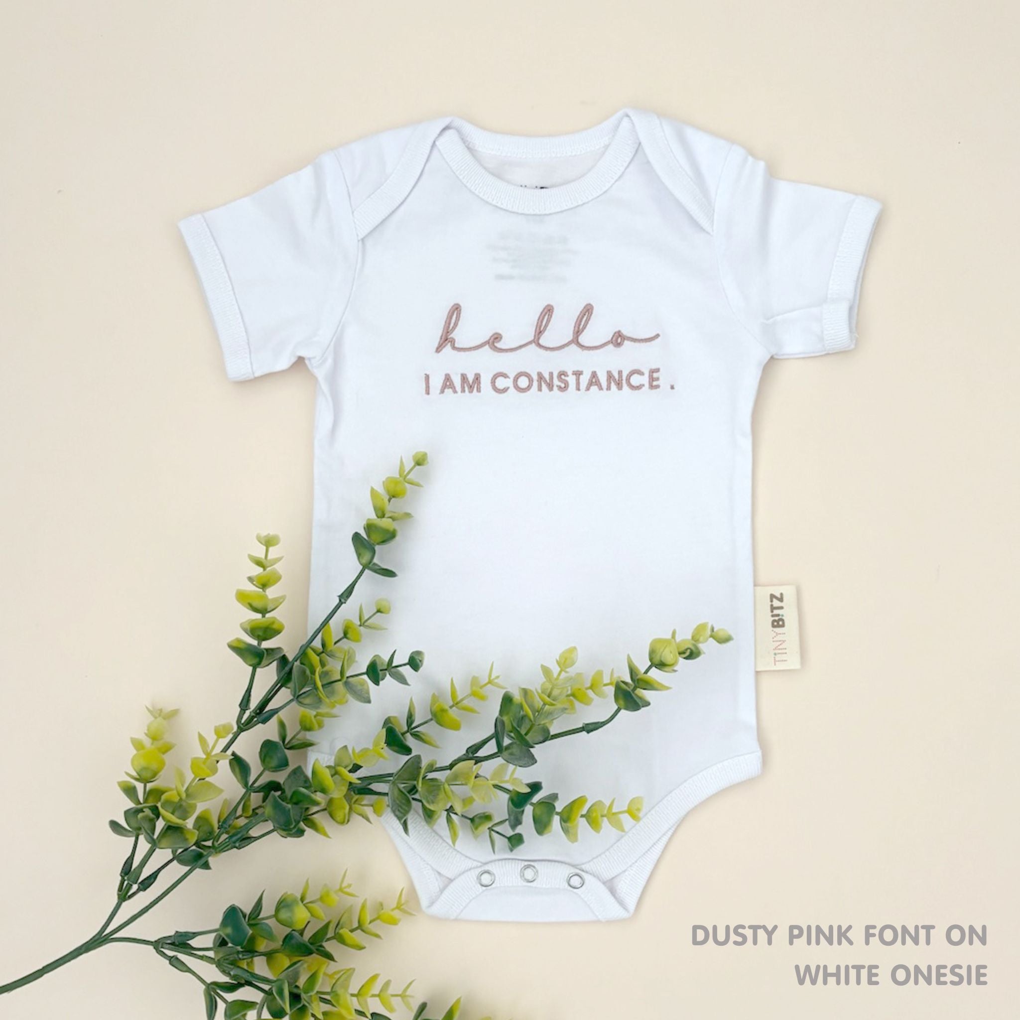 Organic cotton white onesie for babies with embroidered name, personalized baby shower gift keepsake from TinyBitz.