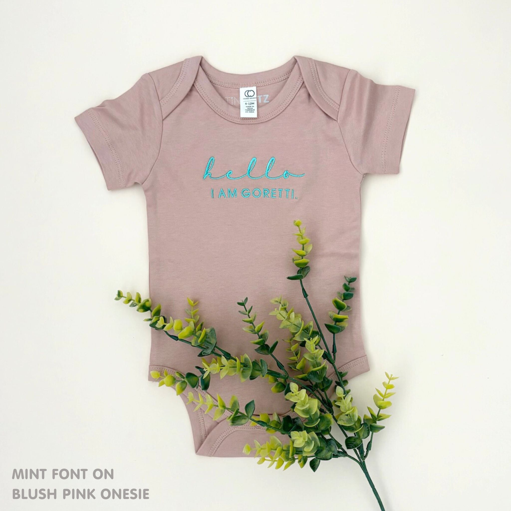 Organic cotton blush pink onesie for babies with embroidered name, personalized baby shower gift keepsake from TinyBitz.