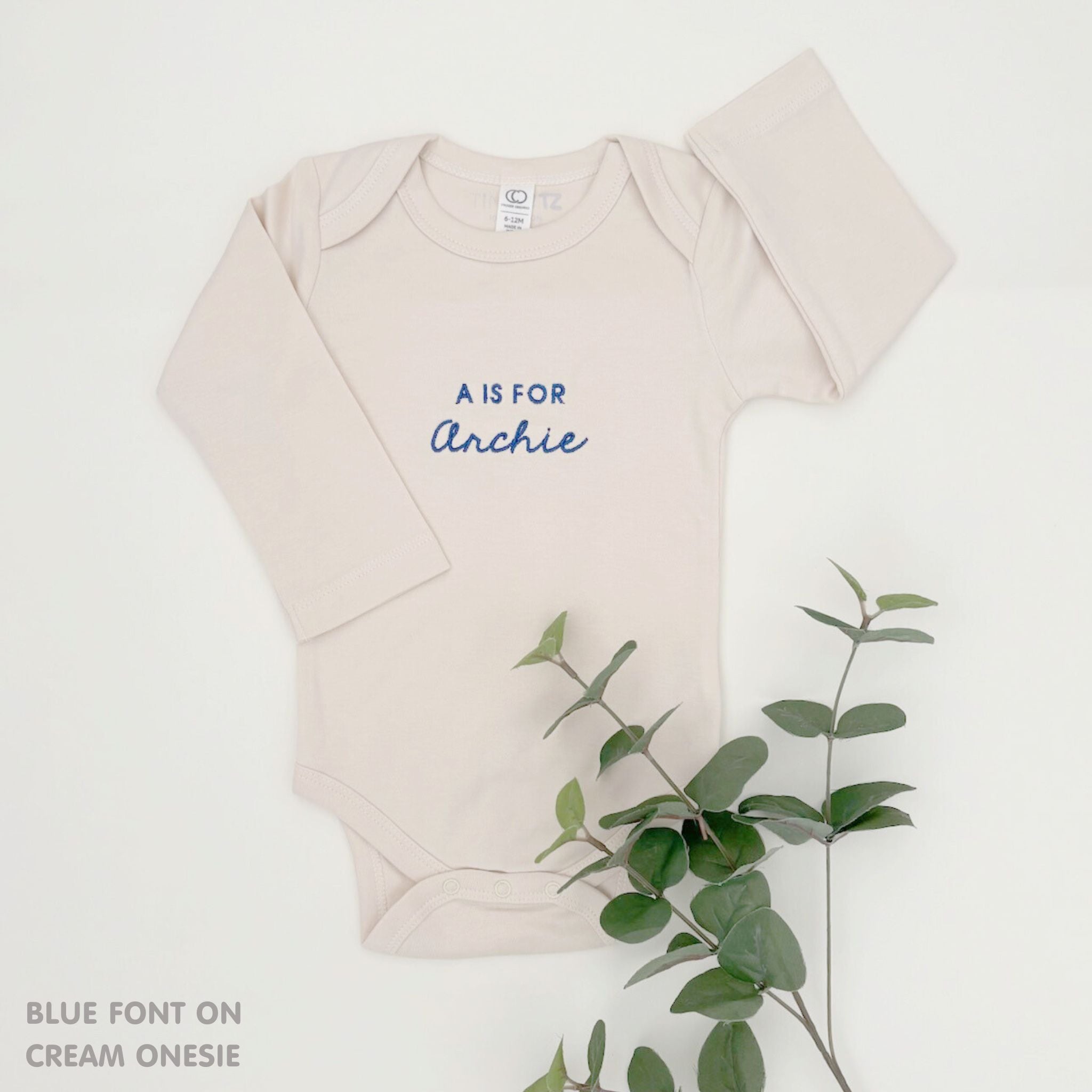Organic cotton cream onesie for babies with embroidered name, personalized baby shower gift keepsake from TinyBitz.