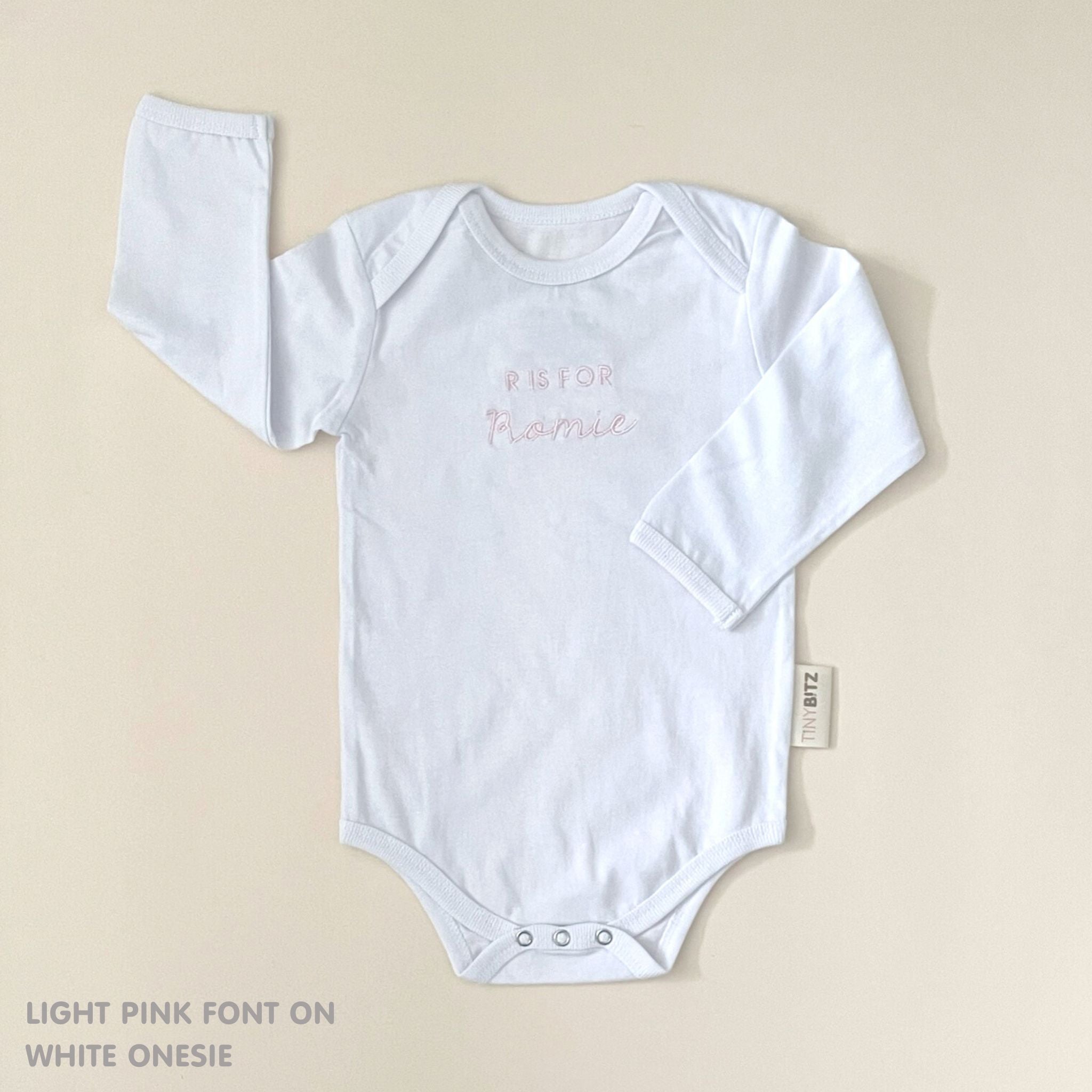 TinyBitz Custom baby onesie in white with name embroidery, unique outfit for baby’s birth announcement or first photoshoot.