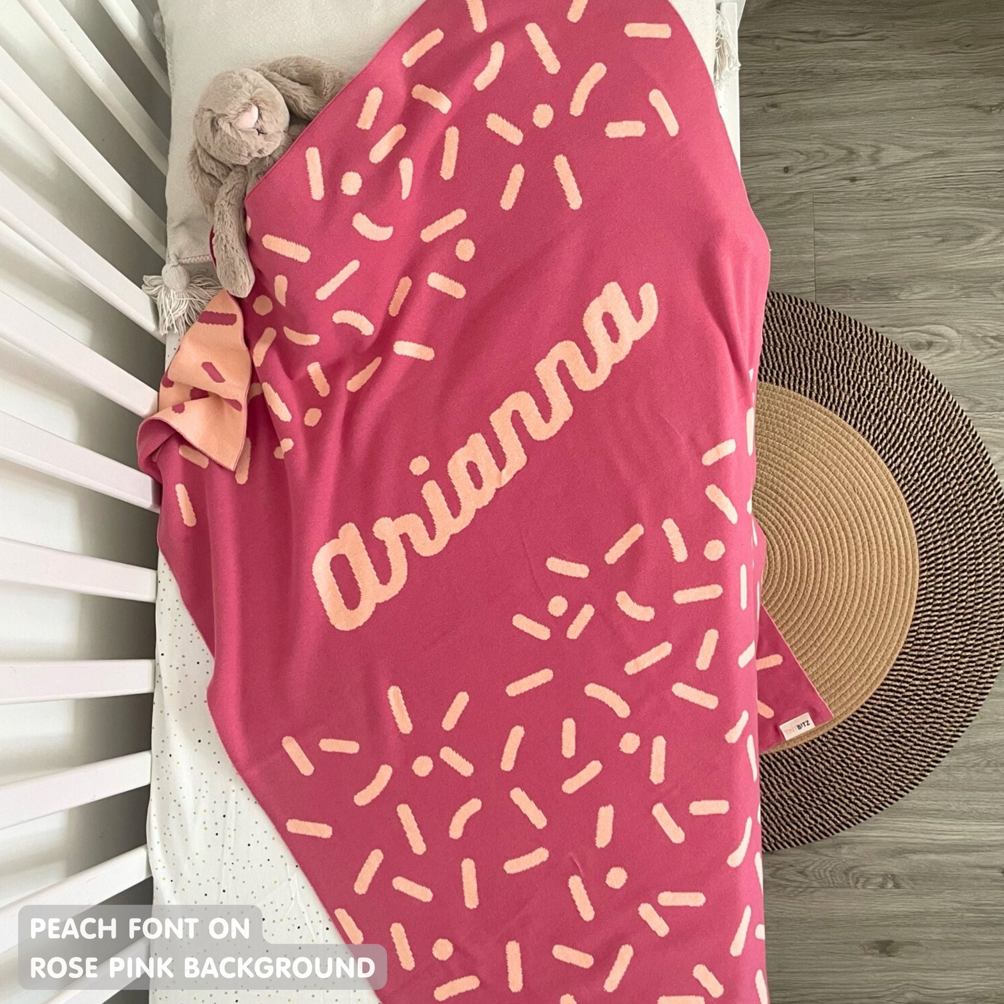 TinyBitz knitted name blanket in rose pink and peach with a confetti pattern, a lovely touch to decorate your baby's room!