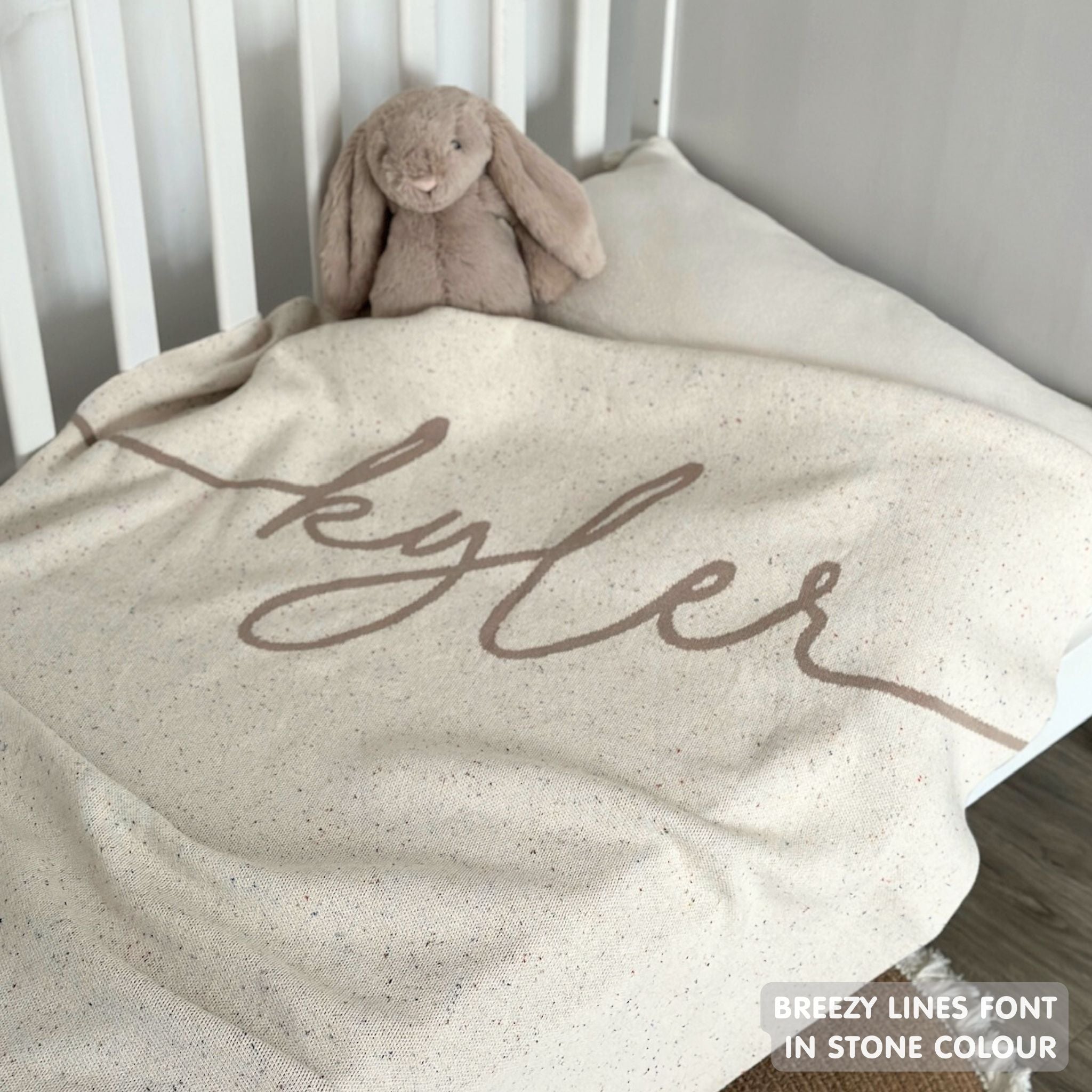 Knitted baby blanket in cream and stone with a confetti pattern, customised with baby's name, made by TinyBitz.