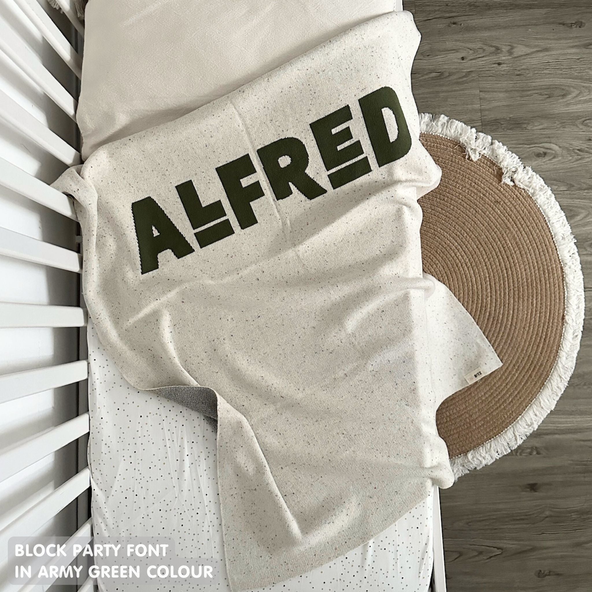 Baby blanket knitted from cotton personalized with baby's name in cream and army green with a confetti pattern, made by TinyBitz.