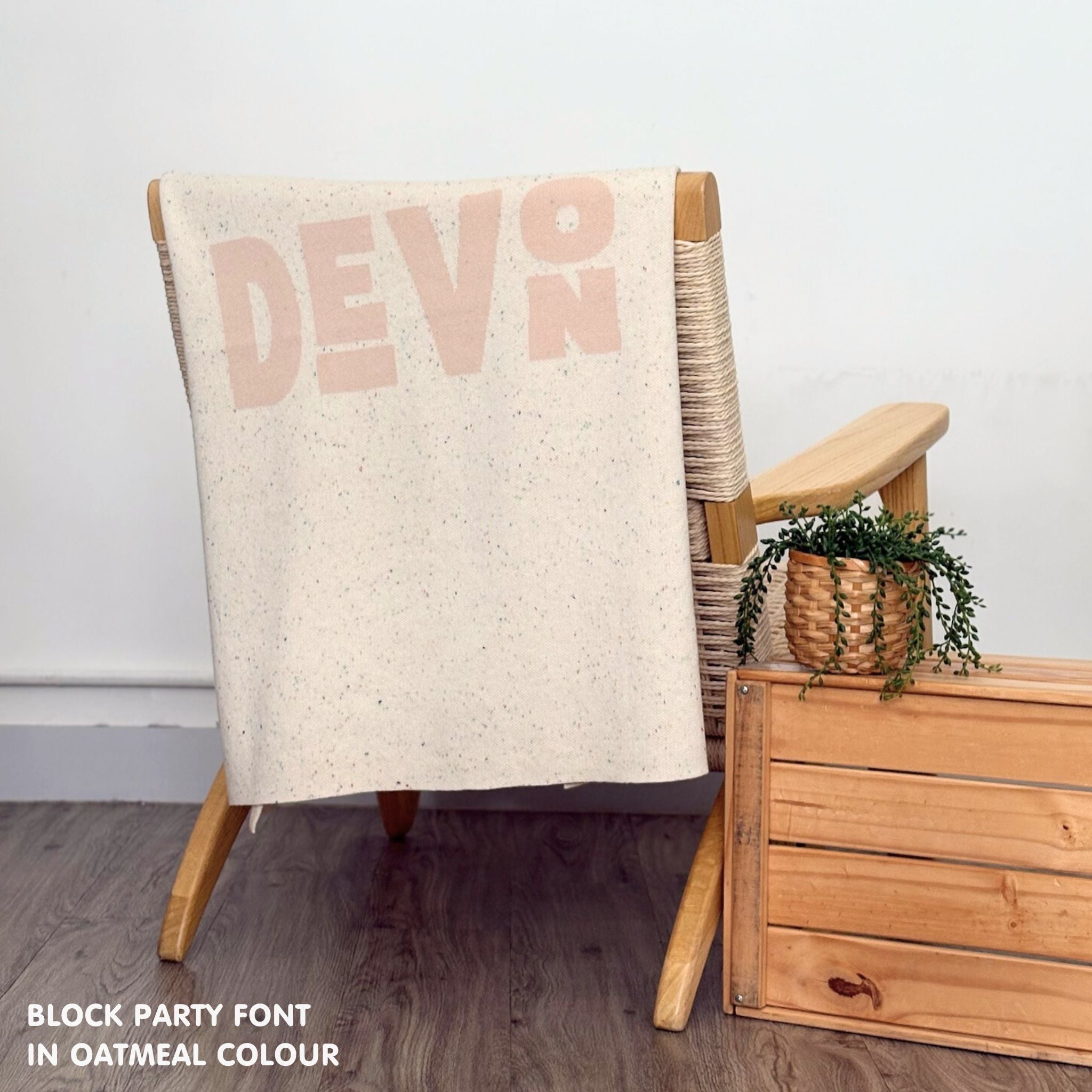 Baby blanket knitted from cotton personalized with baby's name in cream and oatmeal with a confetti pattern, made by TinyBitz.