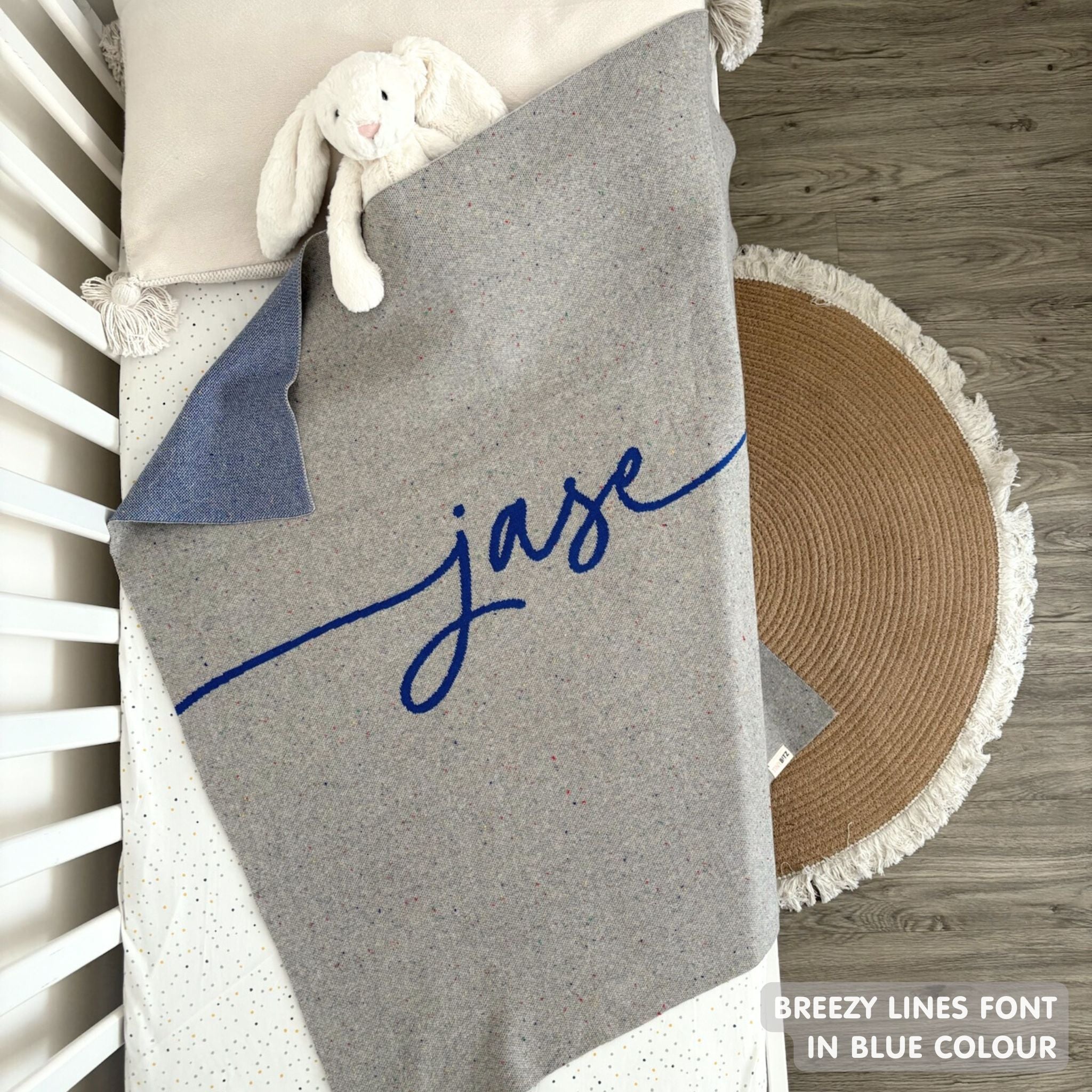 Knitted baby blanket in grey and blue with a confetti pattern, customised with baby's name, made by TinyBitz.