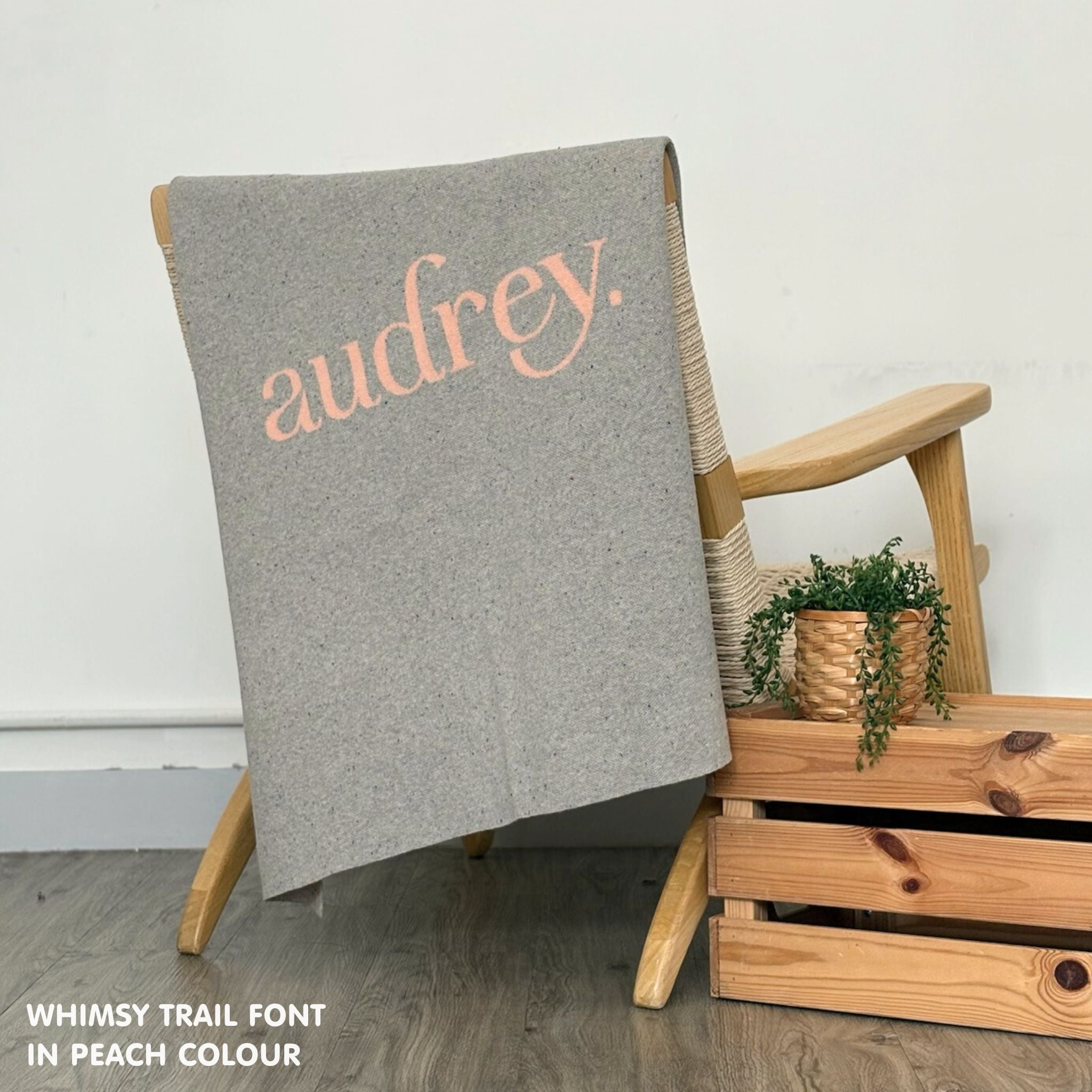 Cotton baby blanket with baby's name knitted in grey and peach with a confetti pattern, made by TinyBitz.