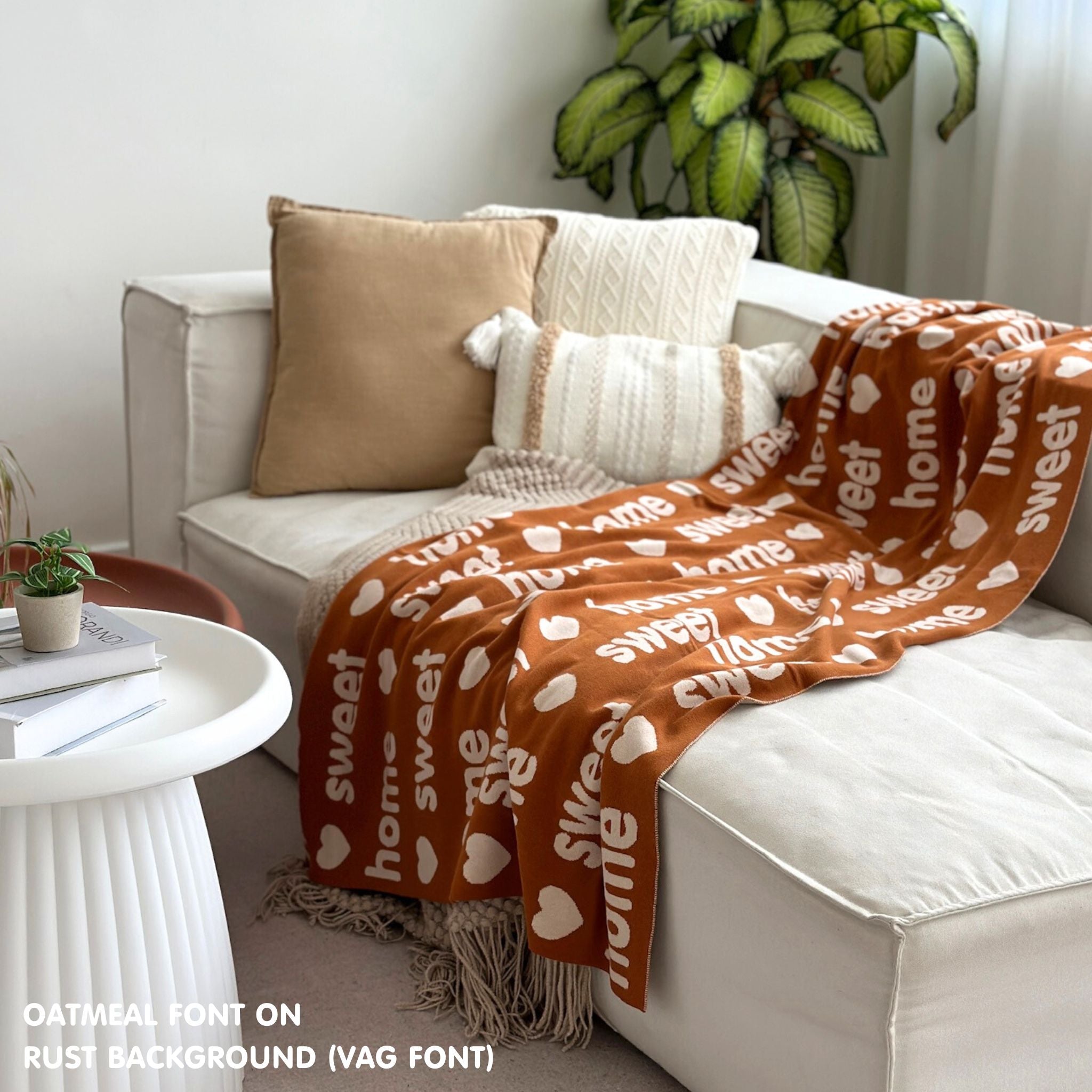 Custom name blanket draped on sofa, knitted in rust and oatmeal makes the best personalised home decor.