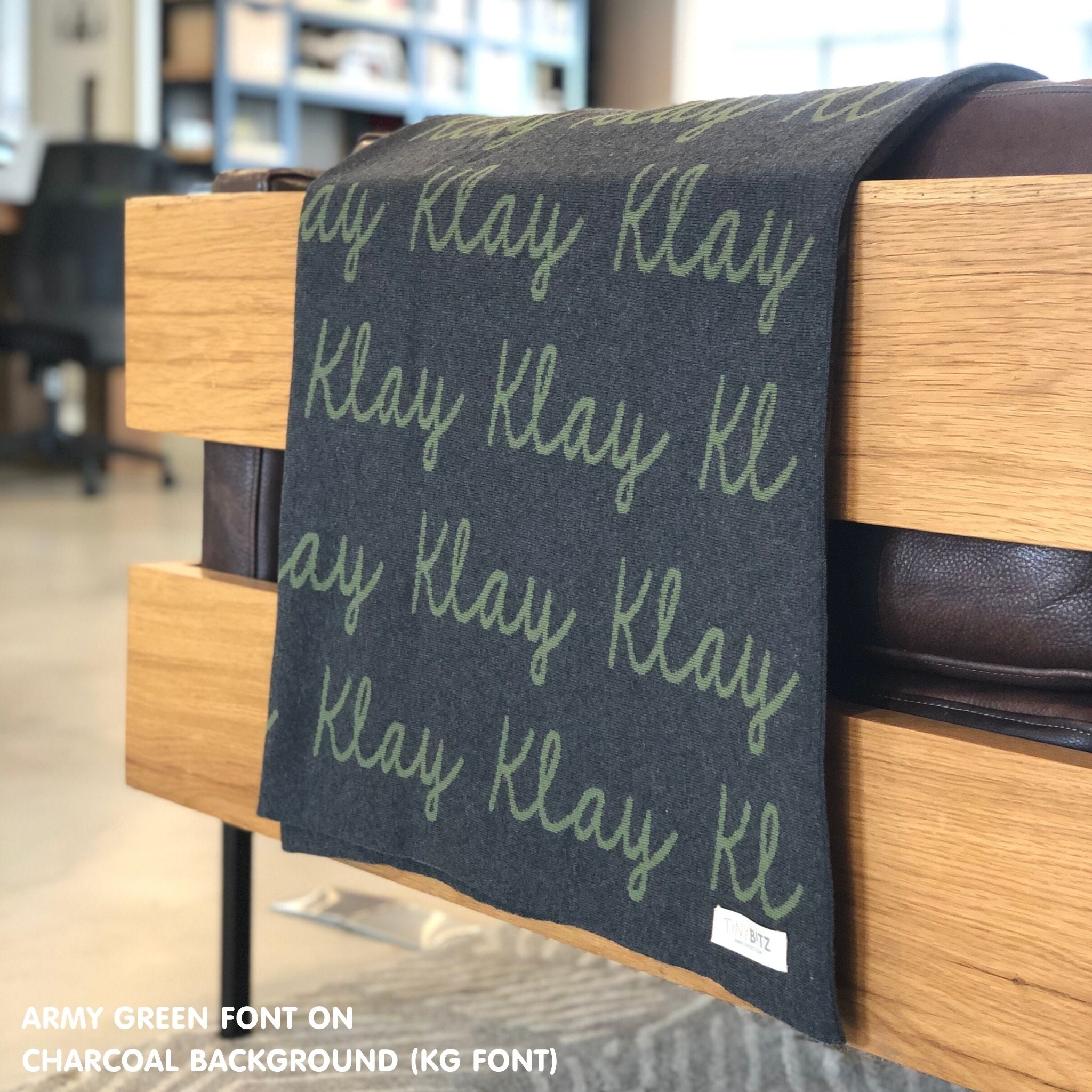 Custom name blanket in charcoal and army green draped over a chair makes the best personalized home decor.