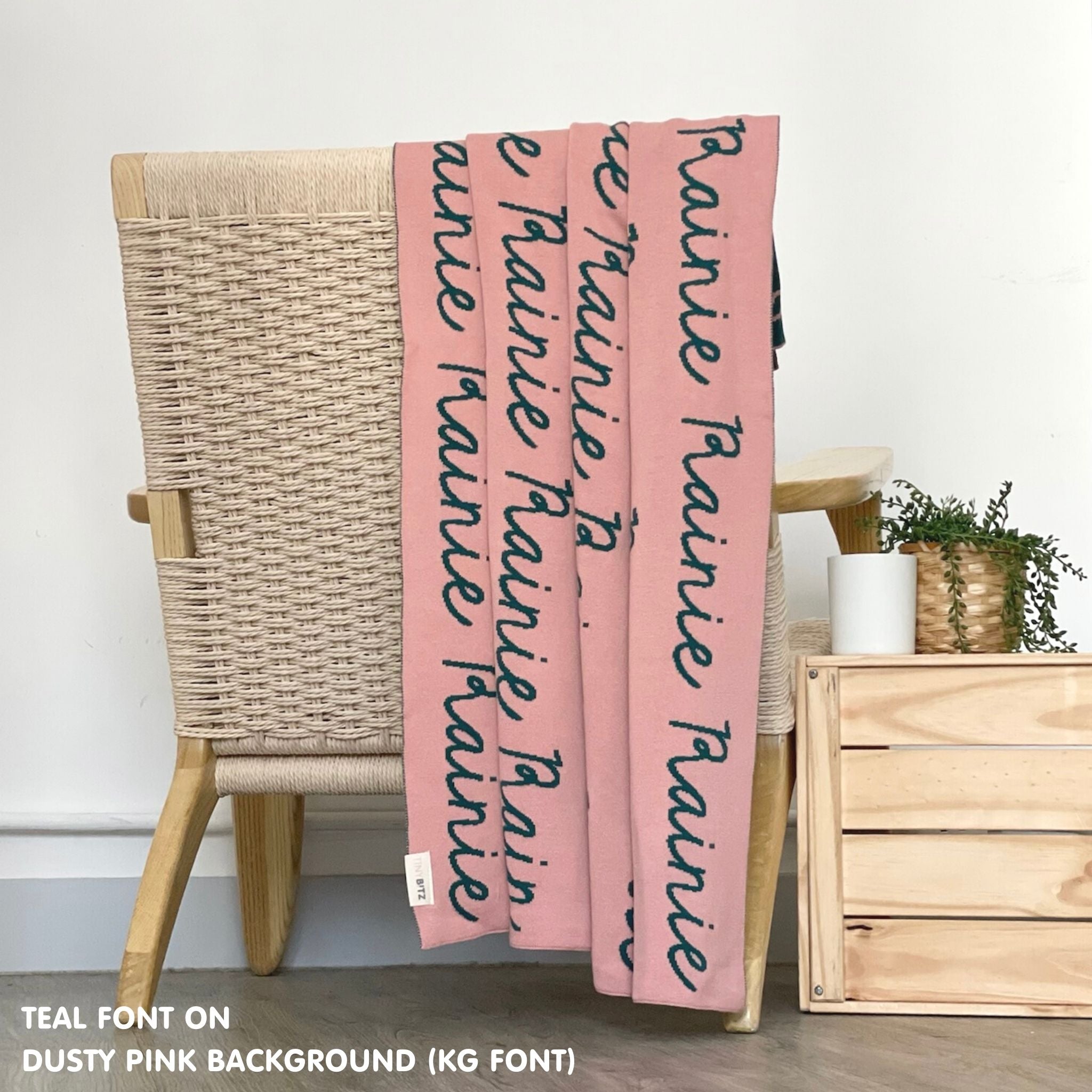 Customisable blanket with adult's name knitted in dusty pink and teal, personalized by TinyBitz.