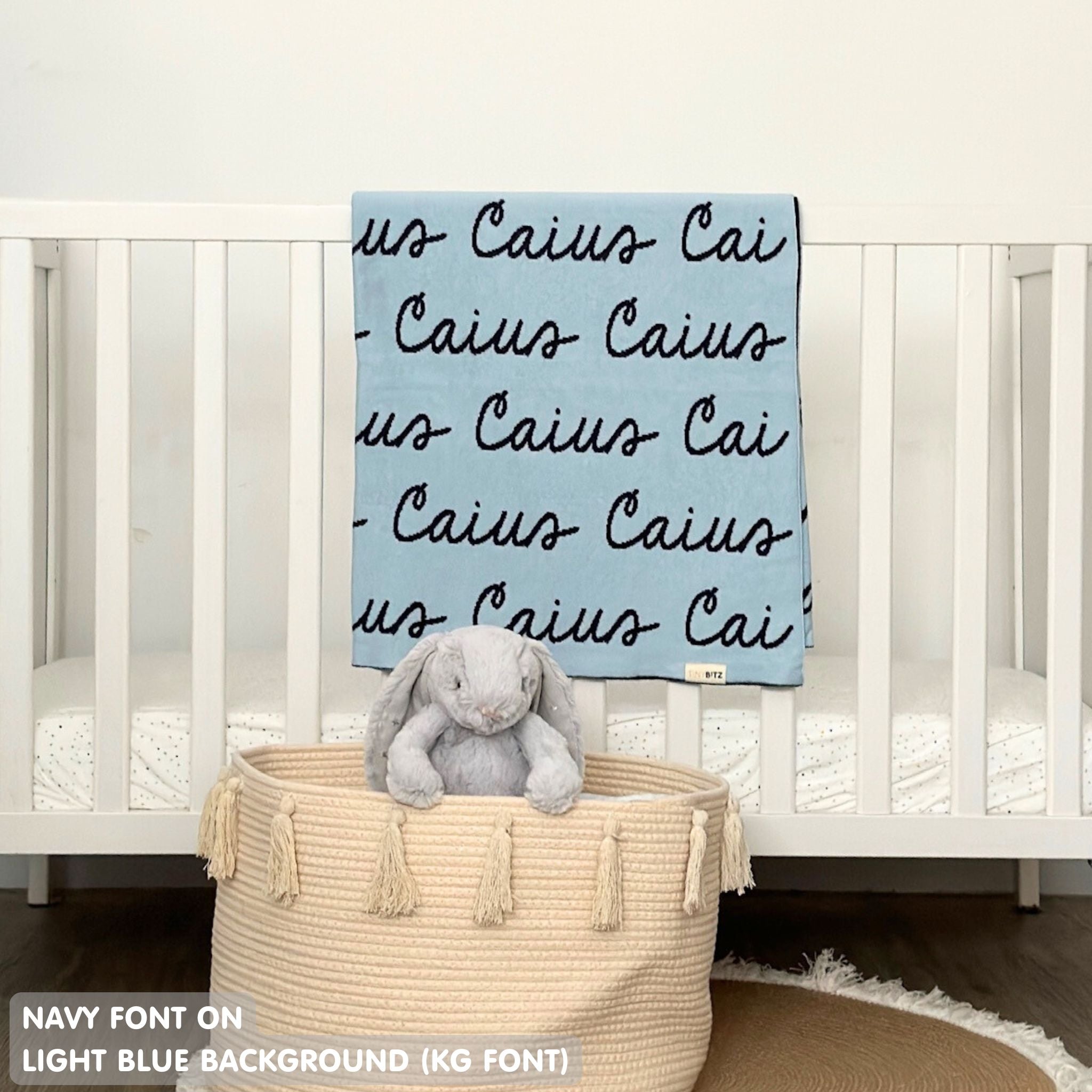 Cotton baby blanket with baby's name knitted in light blue and navy, made by TinyBitz.