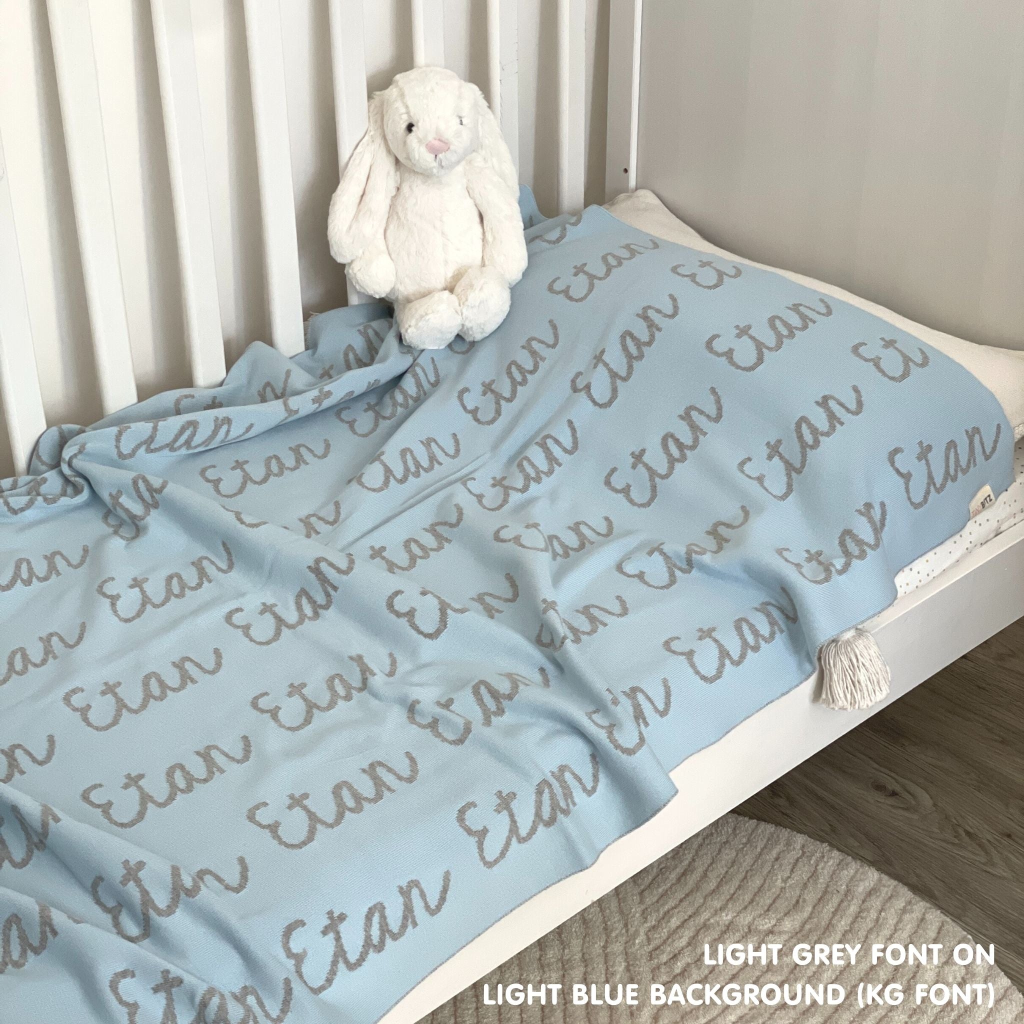 Baby blanket knitted from cotton personalized with baby's name in light blue and light grey, made by TinyBitz.