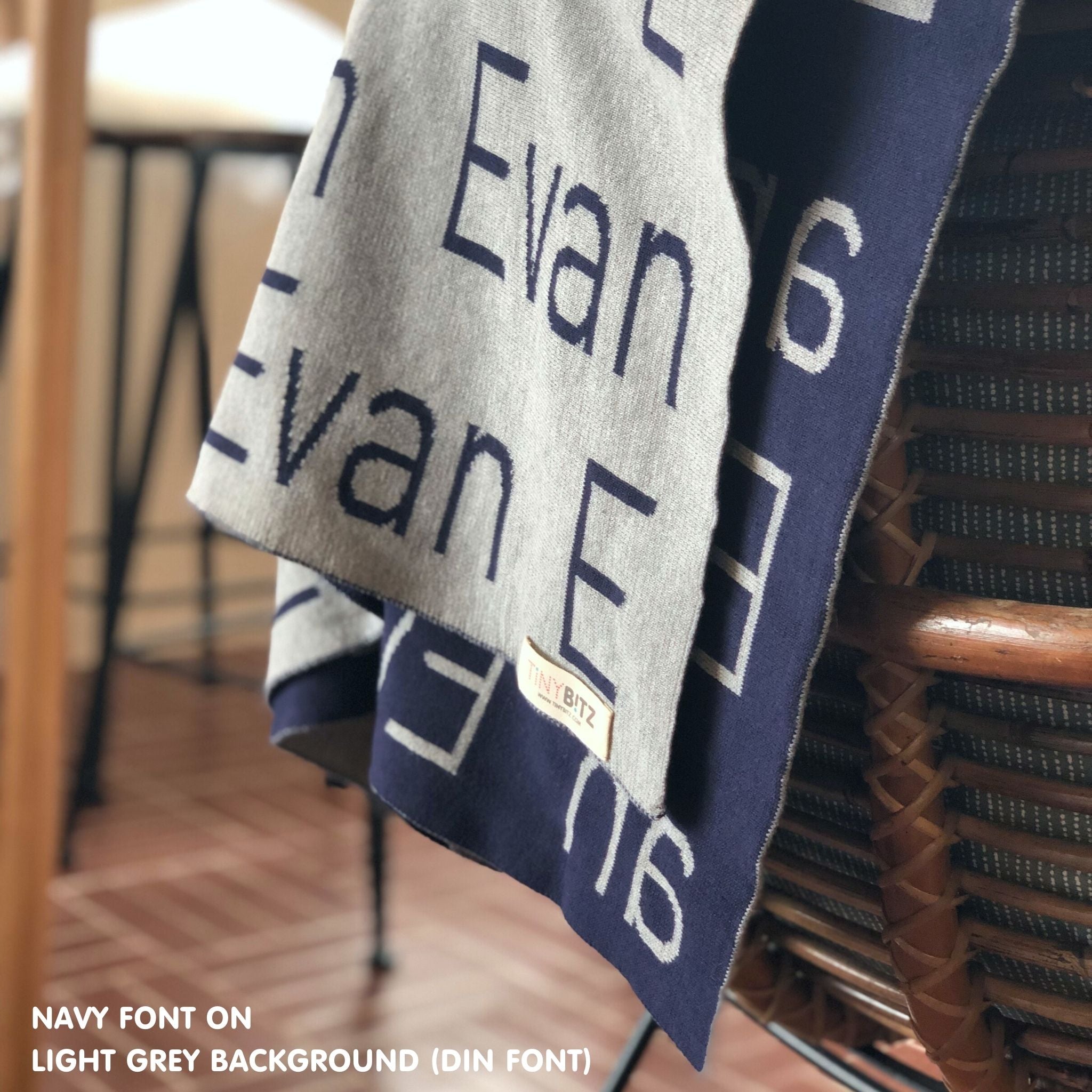 Knitted baby blanket in light grey and navy, customised with baby's name, made by TinyBitz.