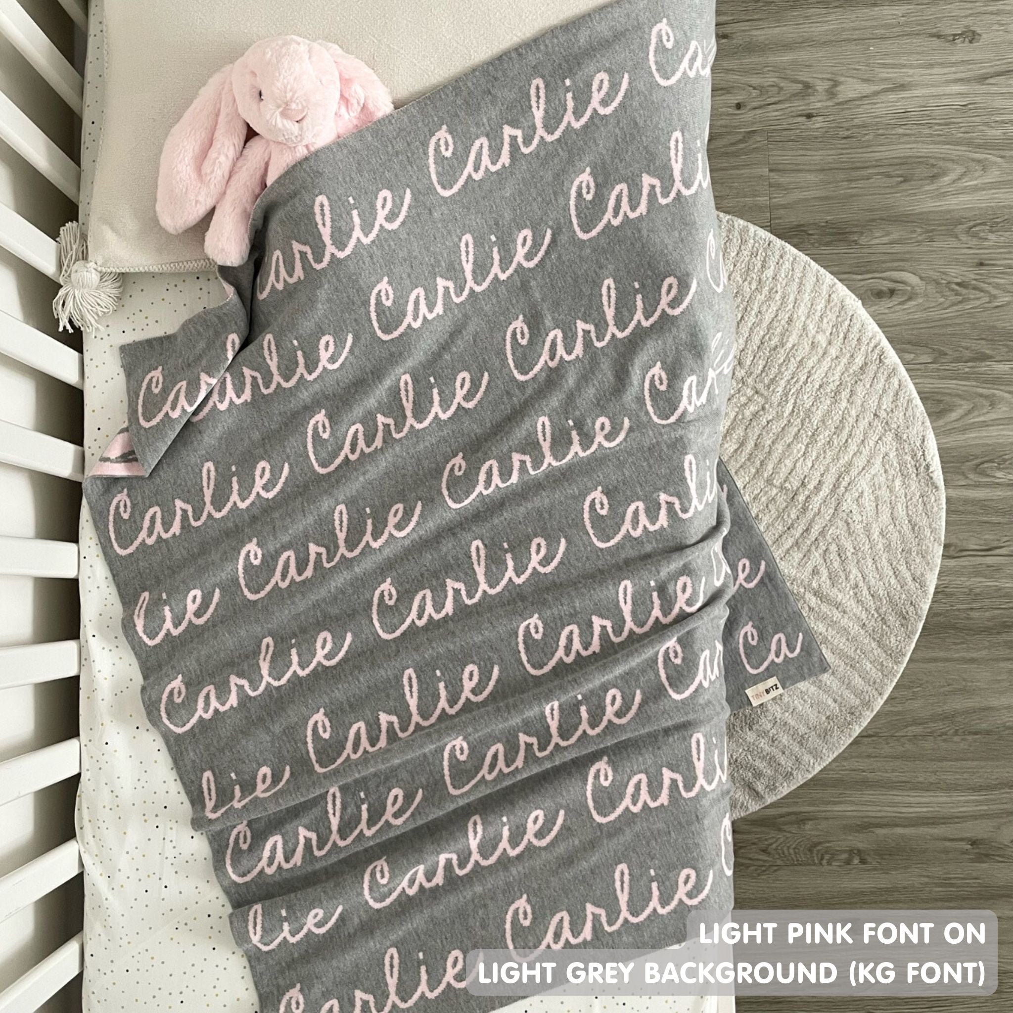 TinyBitz knitted baby girls blanket in light grey background and light pink, personalized with your baby’s name.