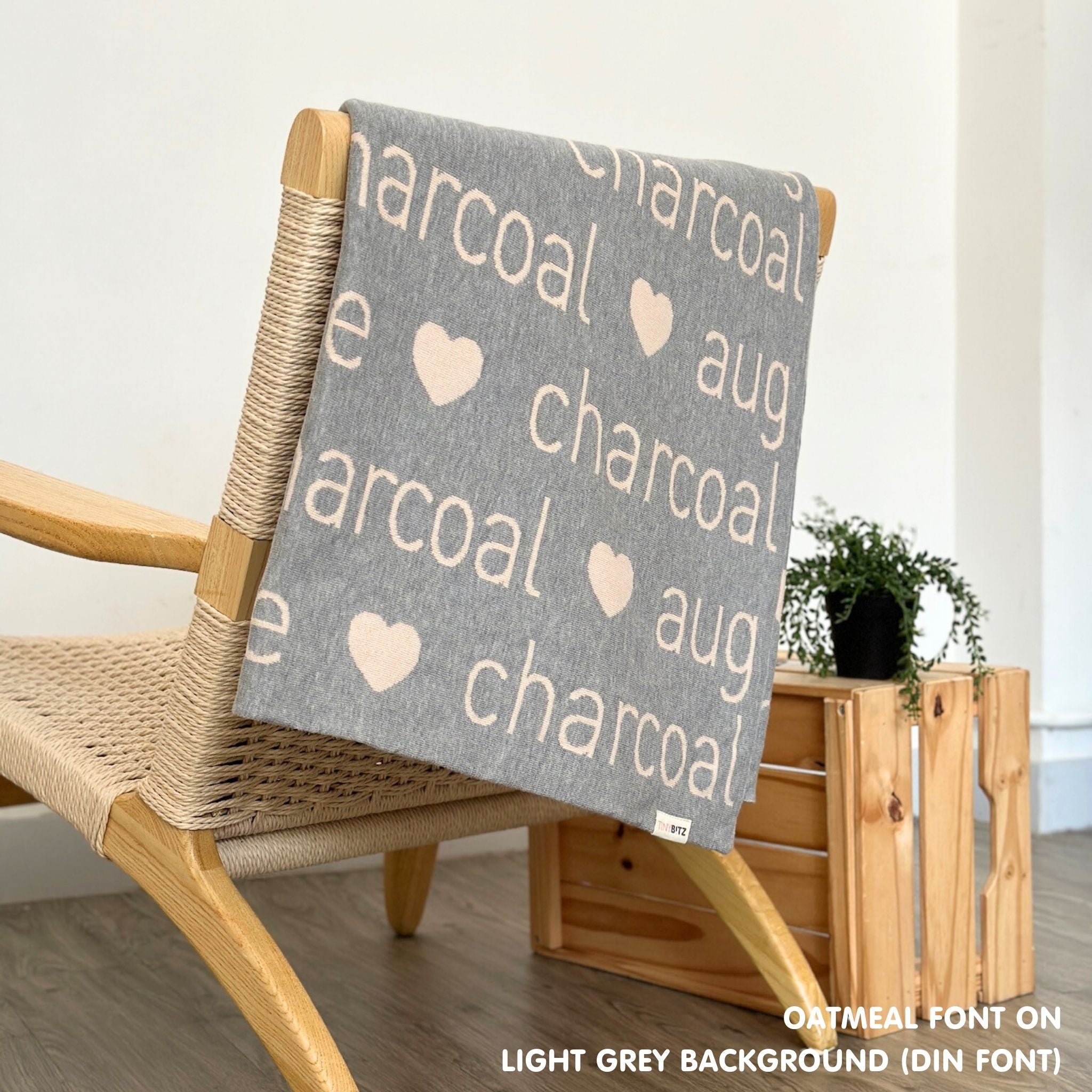 TinyBitz custom name blanket with couple's name knitted in light grey and oatmeal, making the perfect wedding or anniversary gift!