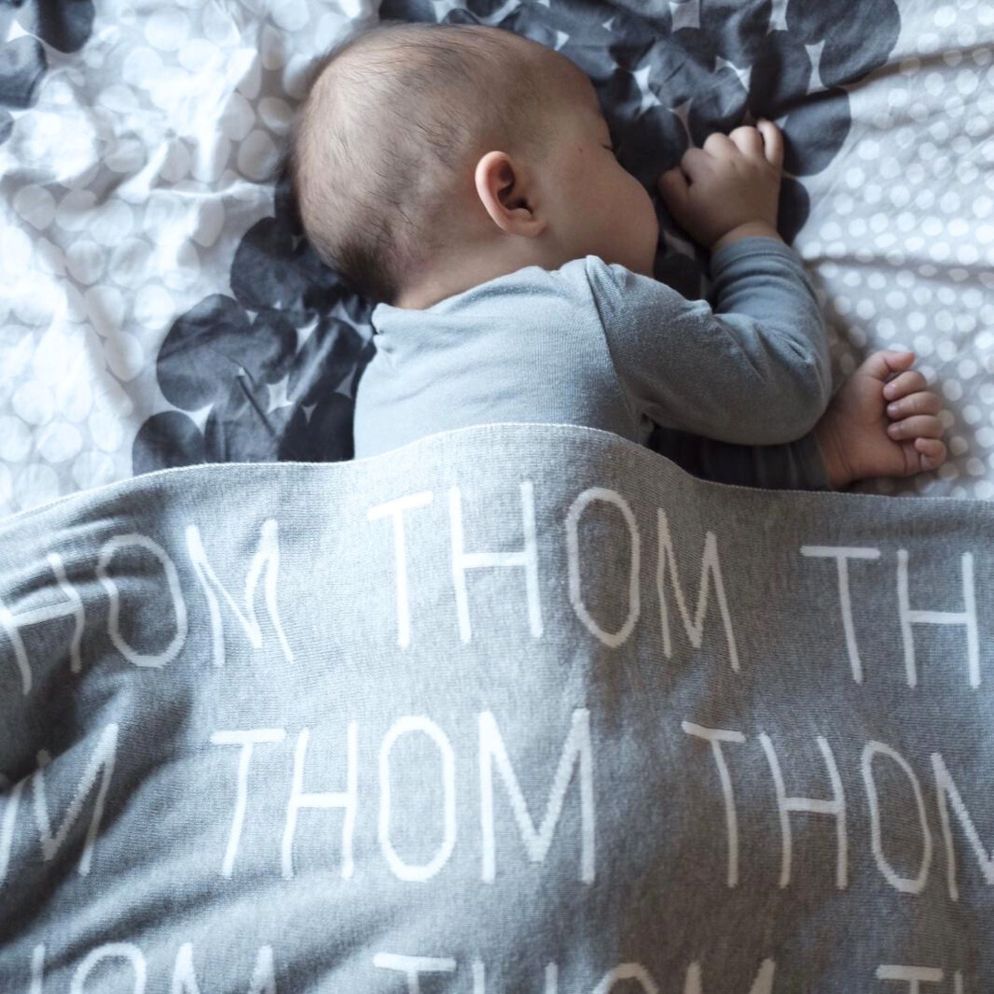 TinyBitz knitted name blanket in light grey and white can be used to decorate your baby's room!