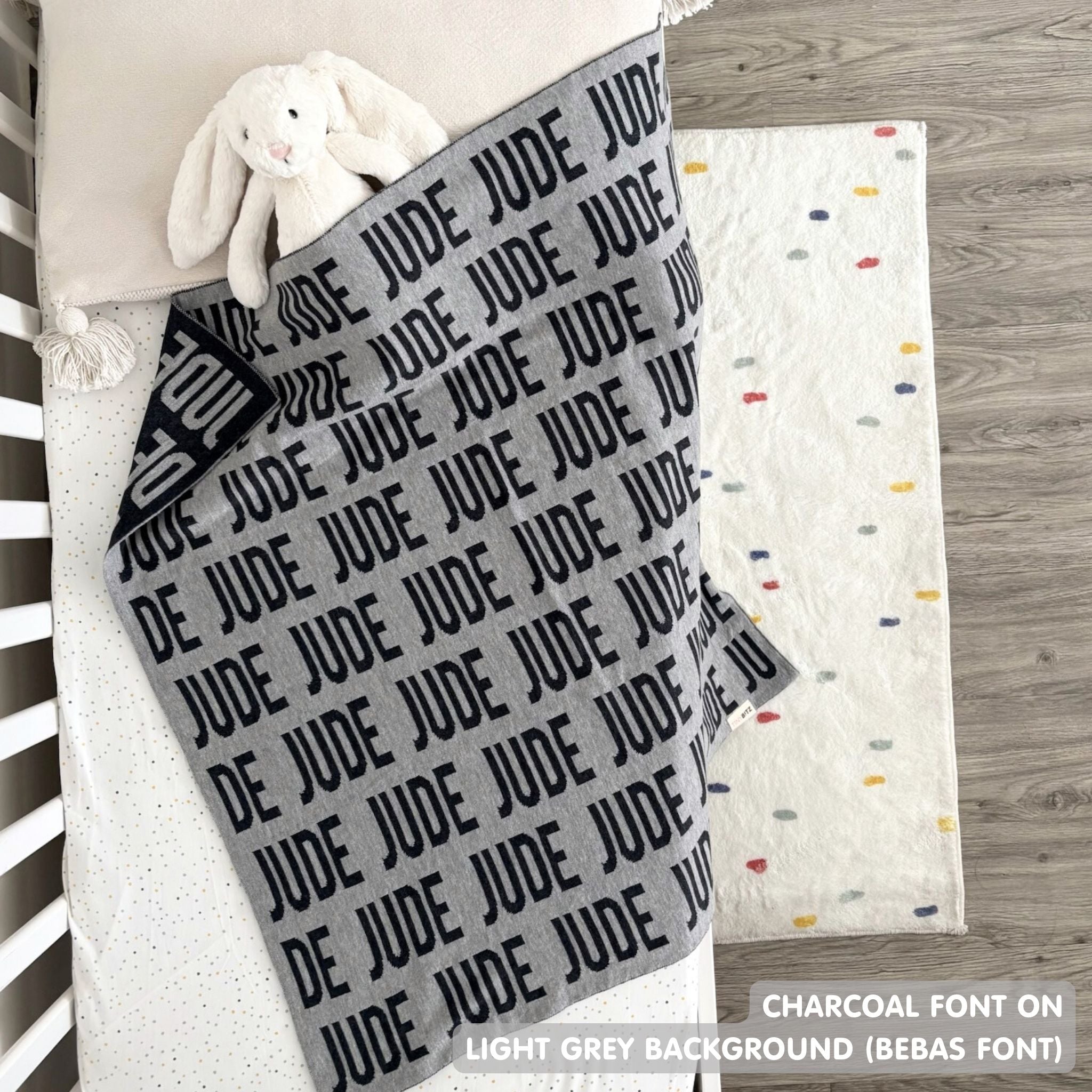 Cotton baby blanket with baby's name knitted in light grey and charcoal, made by TinyBitz.
