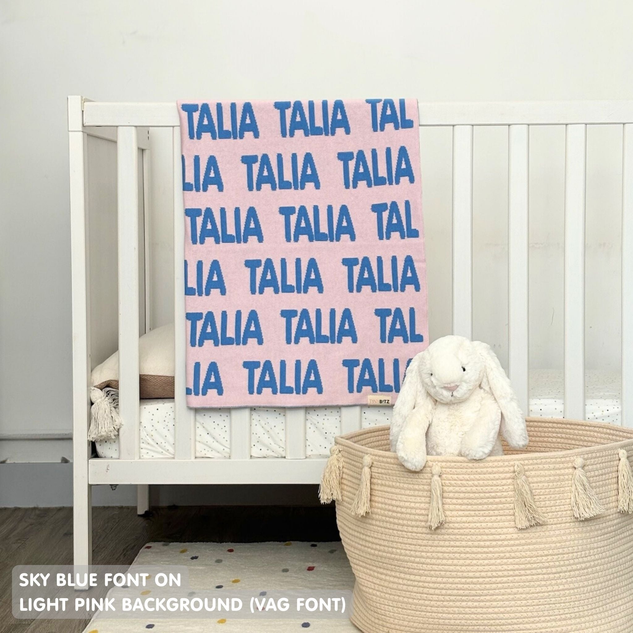 TinyBitz knitted baby girls blanket in light pink background and sky blue, personalized with your baby’s name.