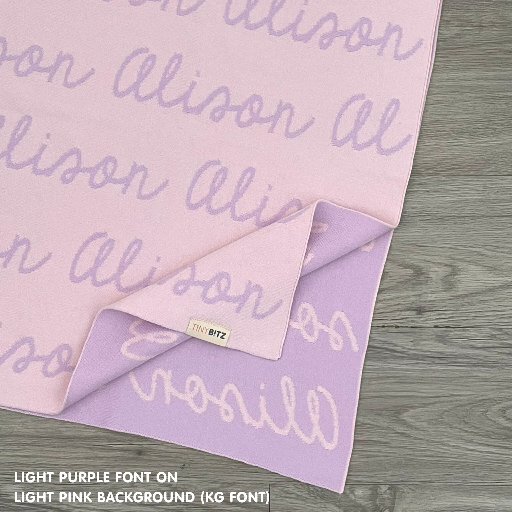 Customisable blanket with adult's name knitted in light pink and light purple, personalized by TinyBitz.