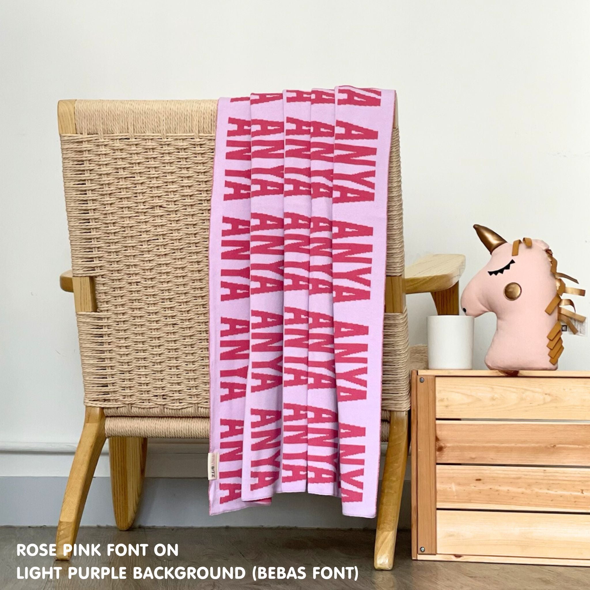 TinyBitz knitted baby boy blanket in light purple background and rose pink, personalized with your baby’s name.