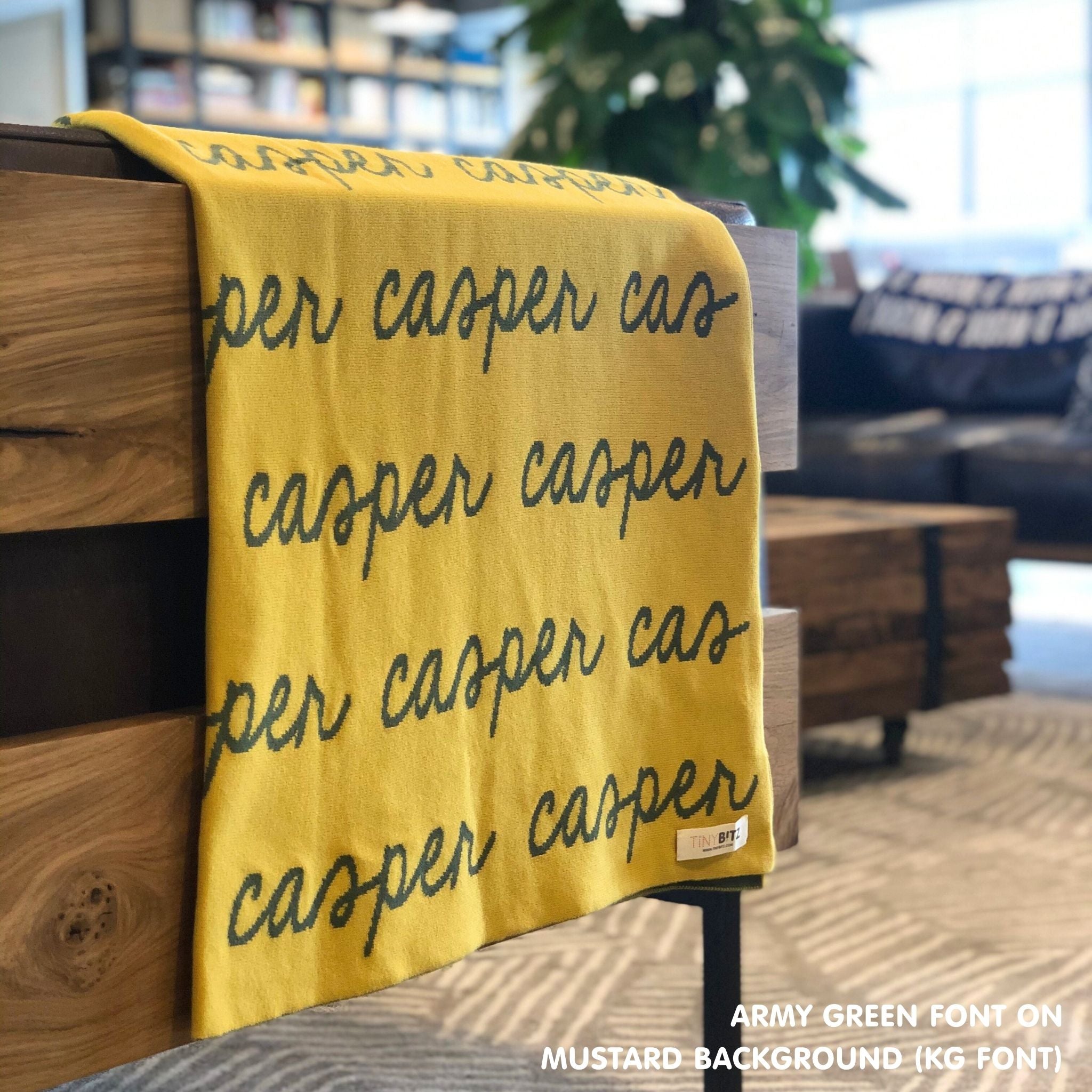 Custom name blanket in mustard and army green draped over a chair makes the best personalized home decor.