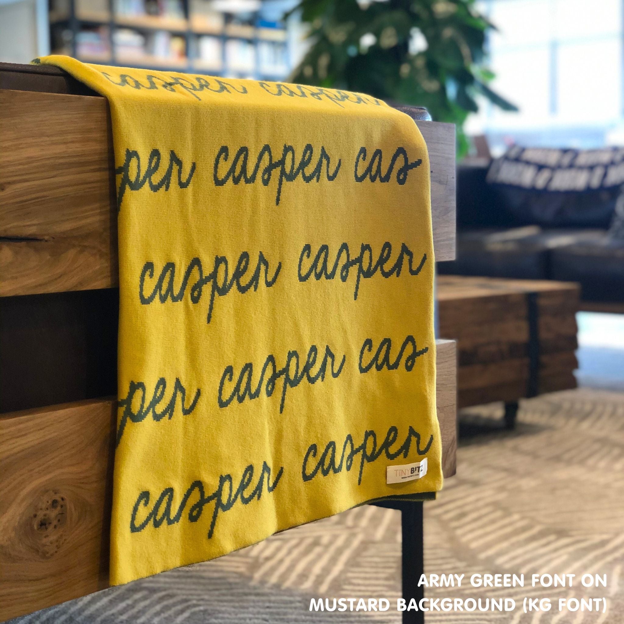 Personalised pet blanket in mustard and army green knitted cotton, custom dog blanket by TinyBitz, styled on modern wooden dog bed.