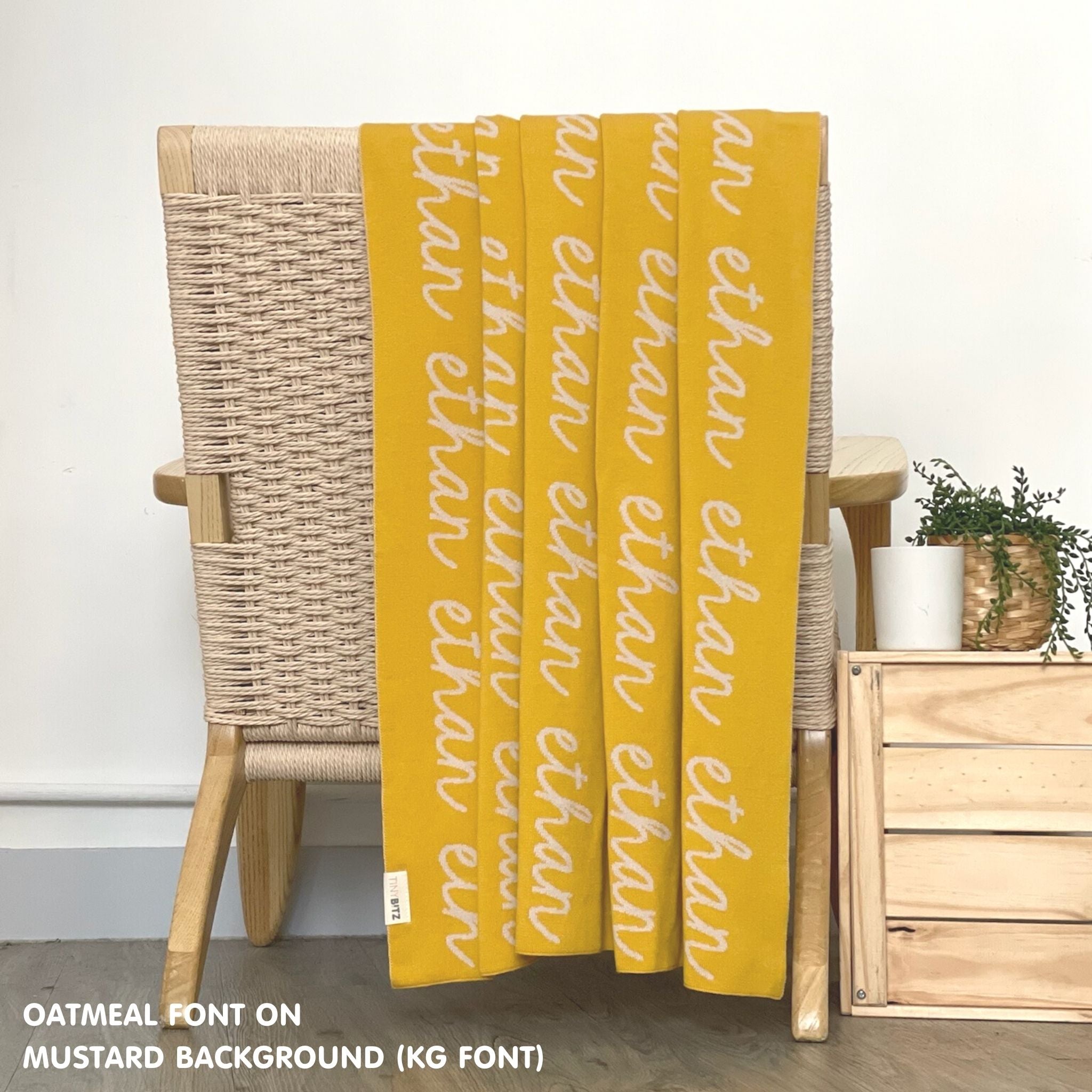 Custom name blanket in mustard and oatmeal draped over a chair makes the best personalized home decor.