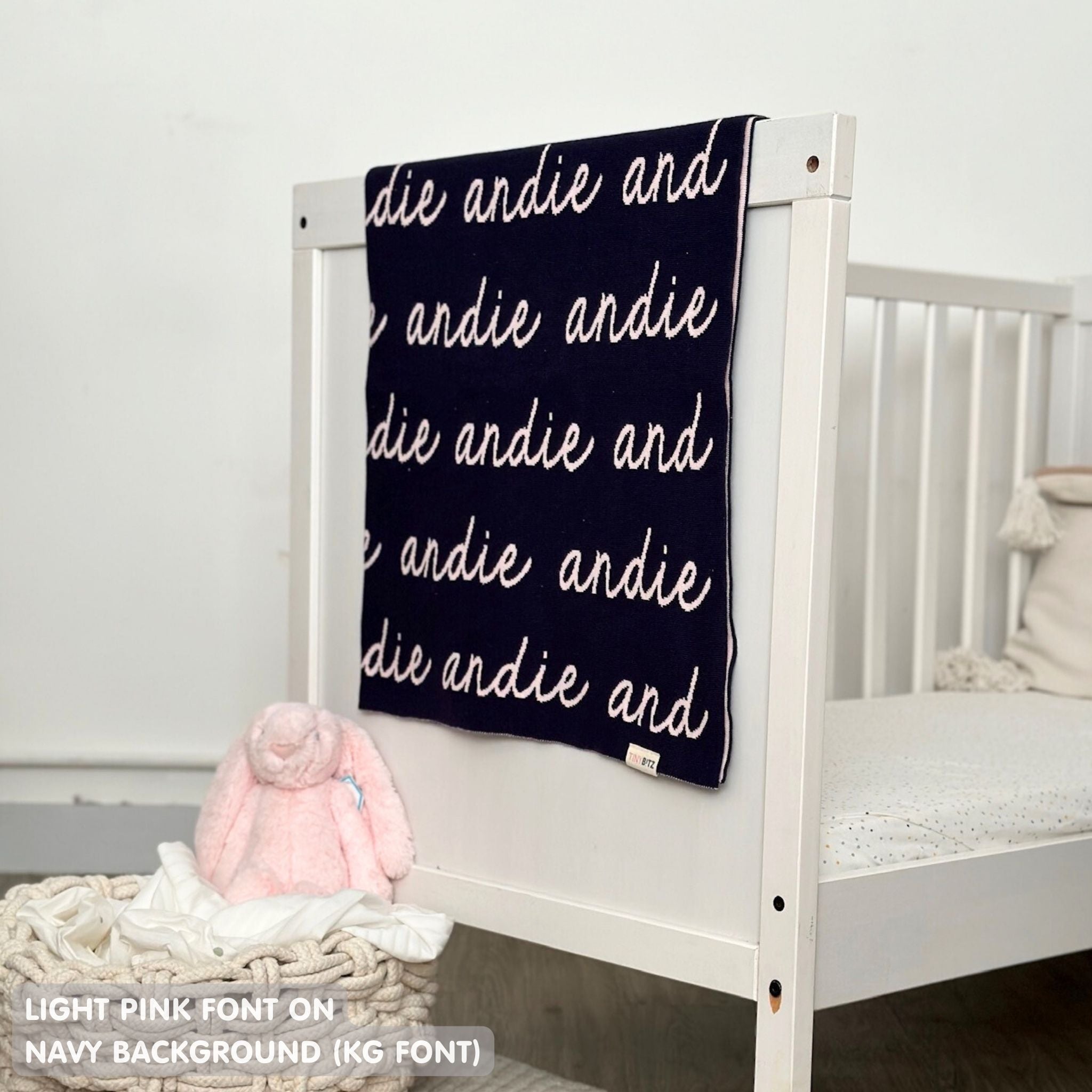 TinyBitz knitted baby girls blanket in navy background and light pink, personalized with your baby’s name.
