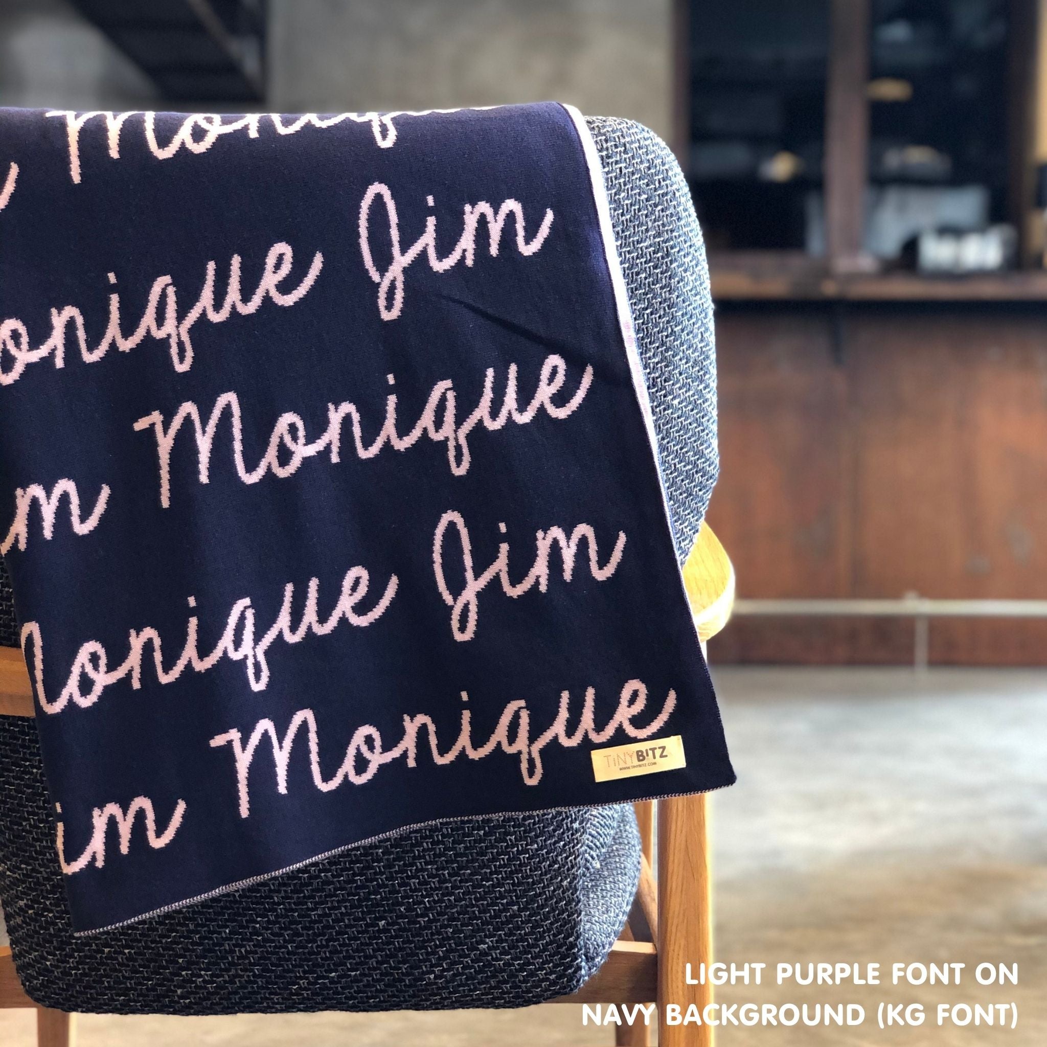 Custom name blanket in navy and light purple draped over a chair makes the best personalized home decor.