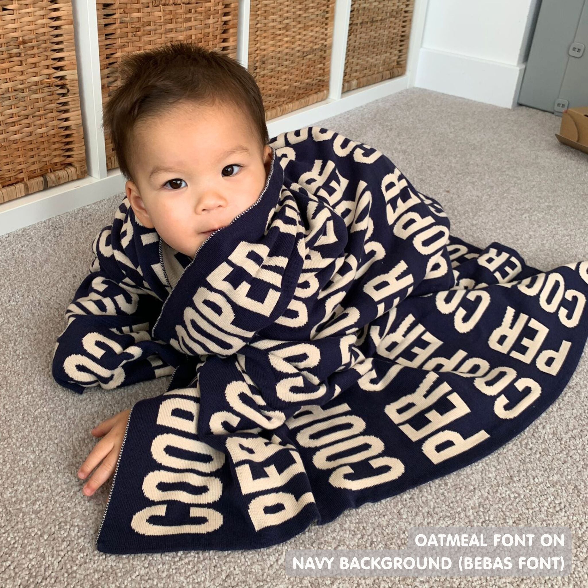 TinyBitz personalized knitted blanket in navy background, customized with baby's name and made from 100% cotton.