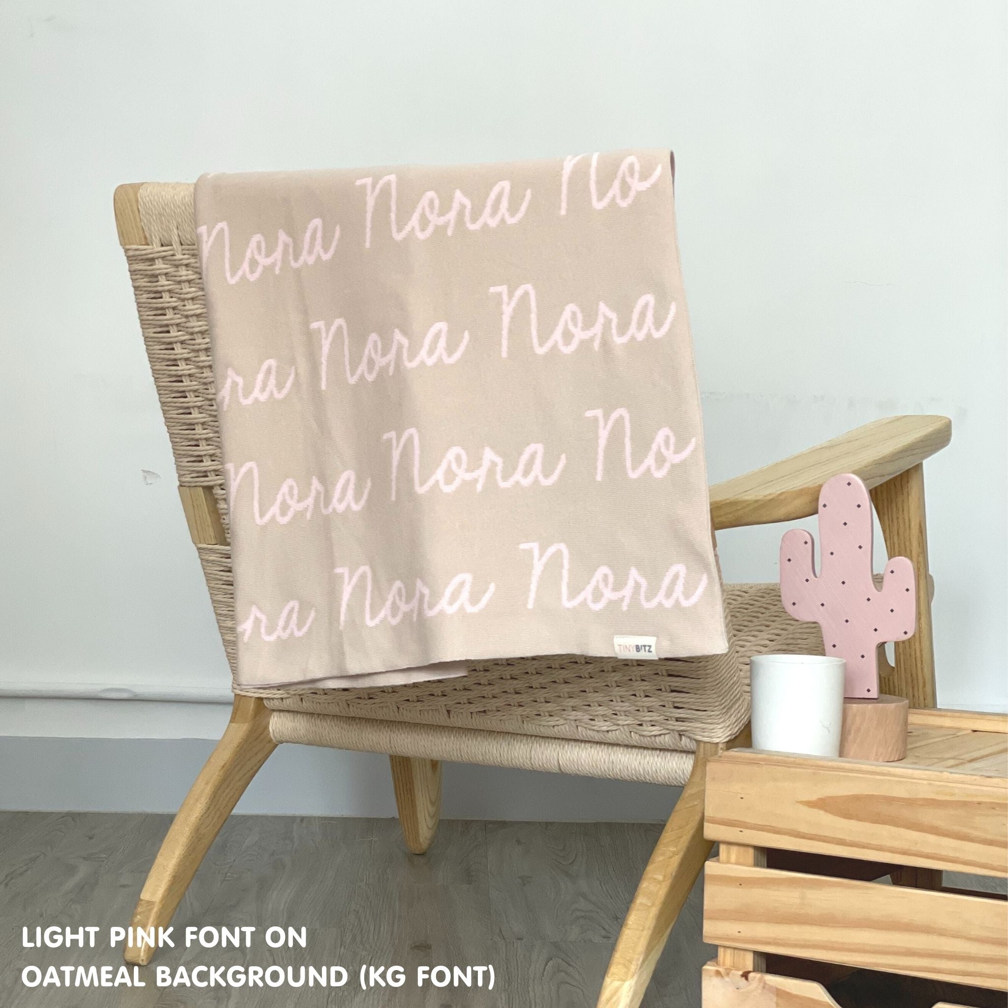 Cotton baby blanket with baby's name knitted in oatmeal and light pink, made by TinyBitz.