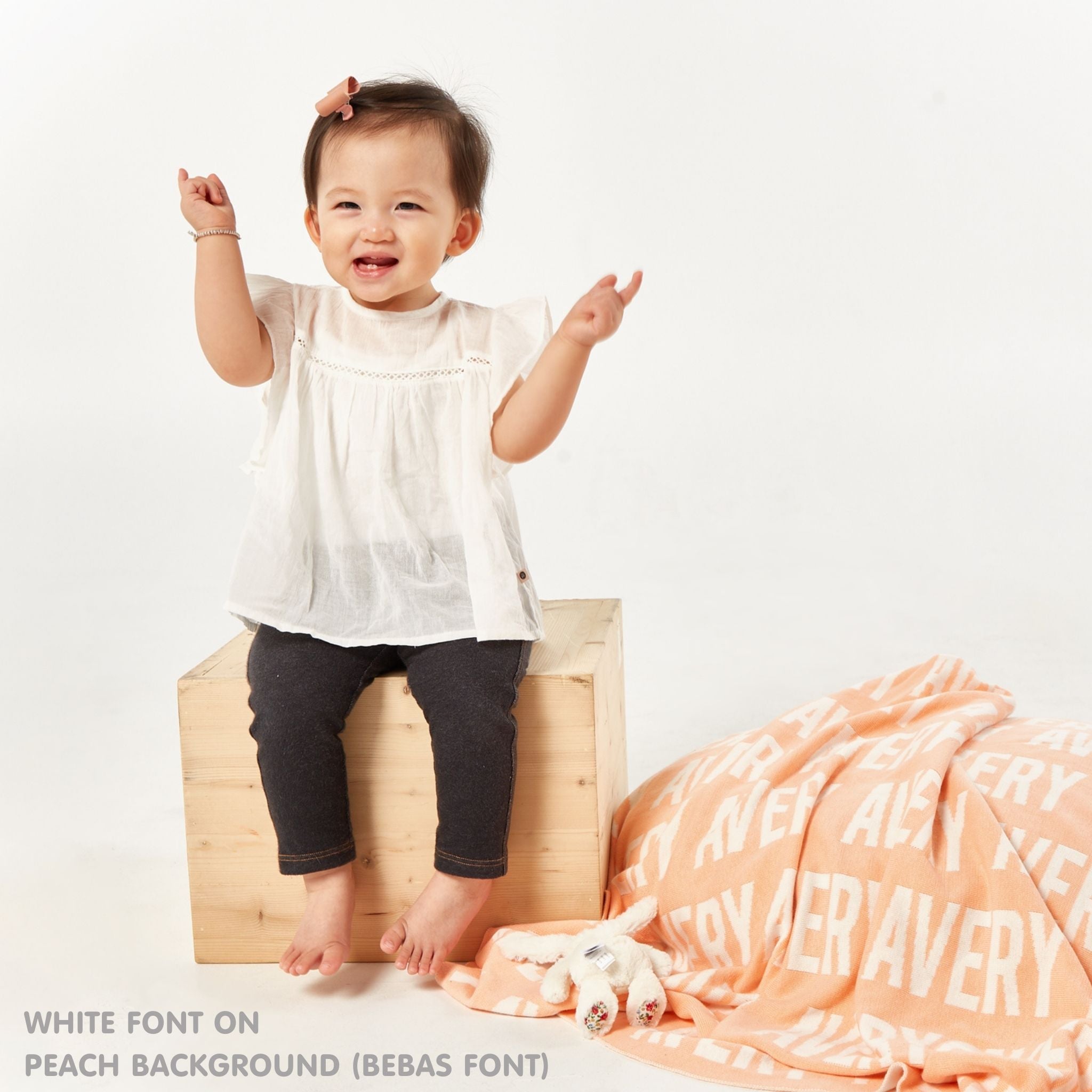 TinyBitz personalized knitted blanket in peach background, customized with baby's name and made from 100% cotton.