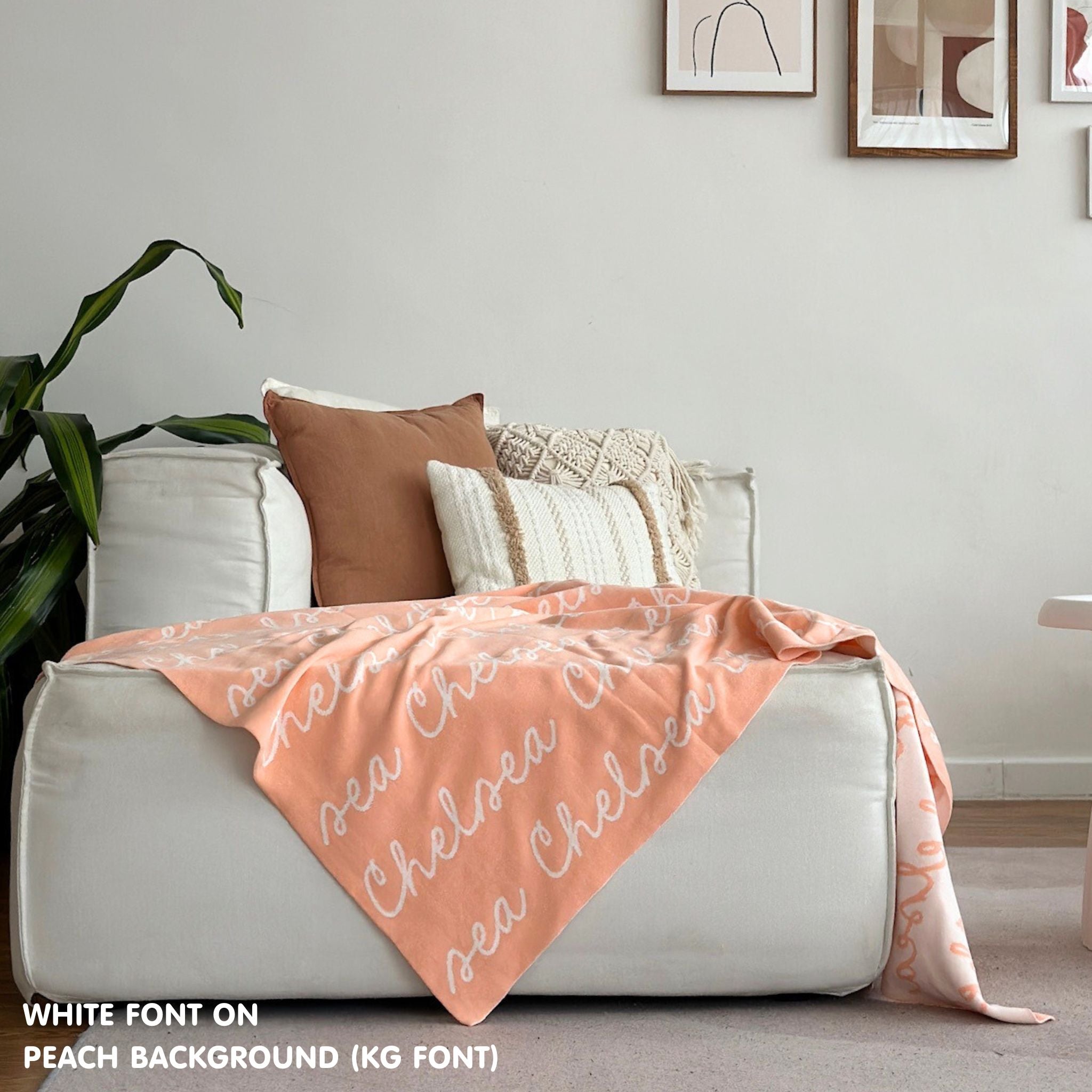 Custom name blanket draped on sofa, knitted in peach and white makes the best personalised home decor.