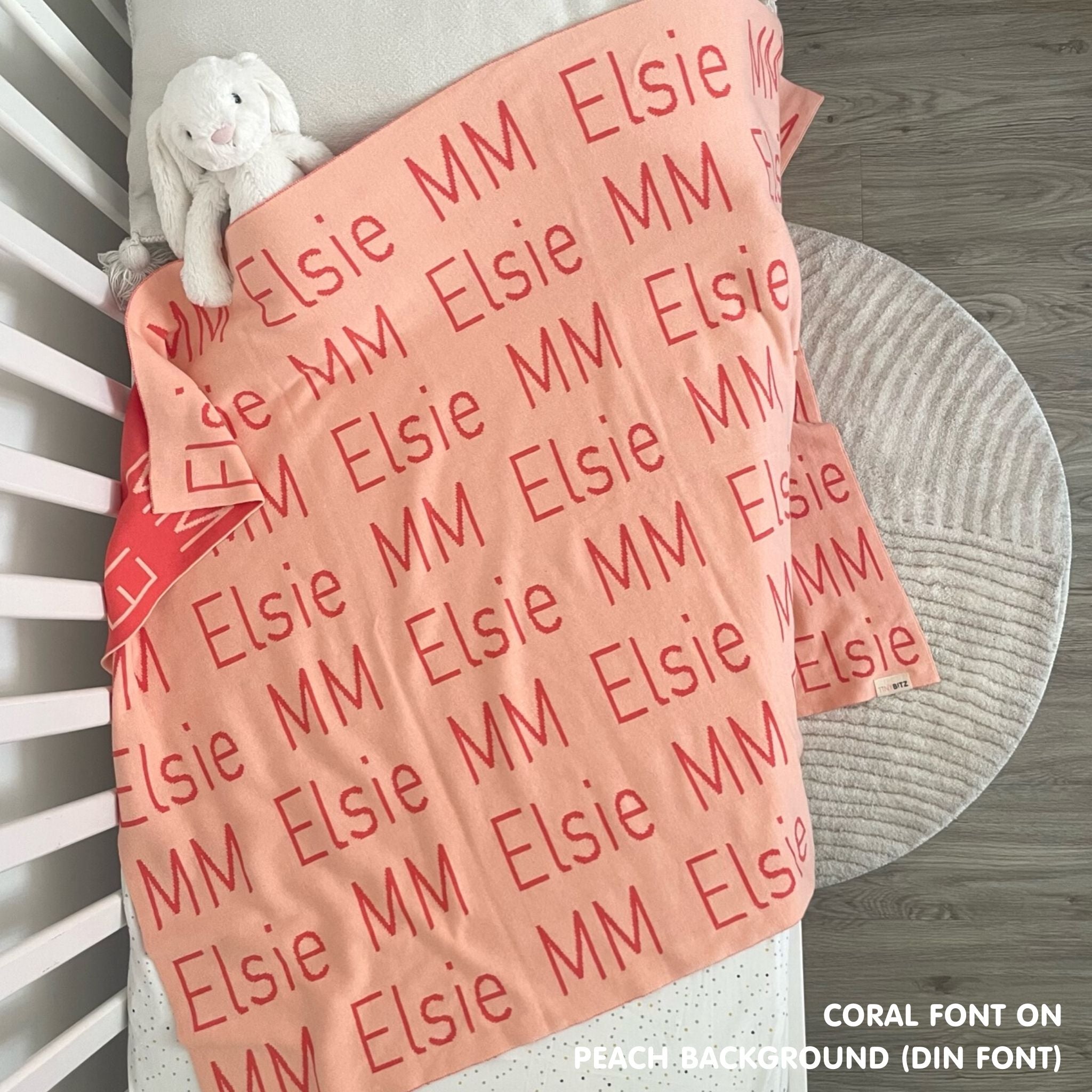 Knitted baby blanket in peach and coral, customised with baby's name, made by TinyBitz.