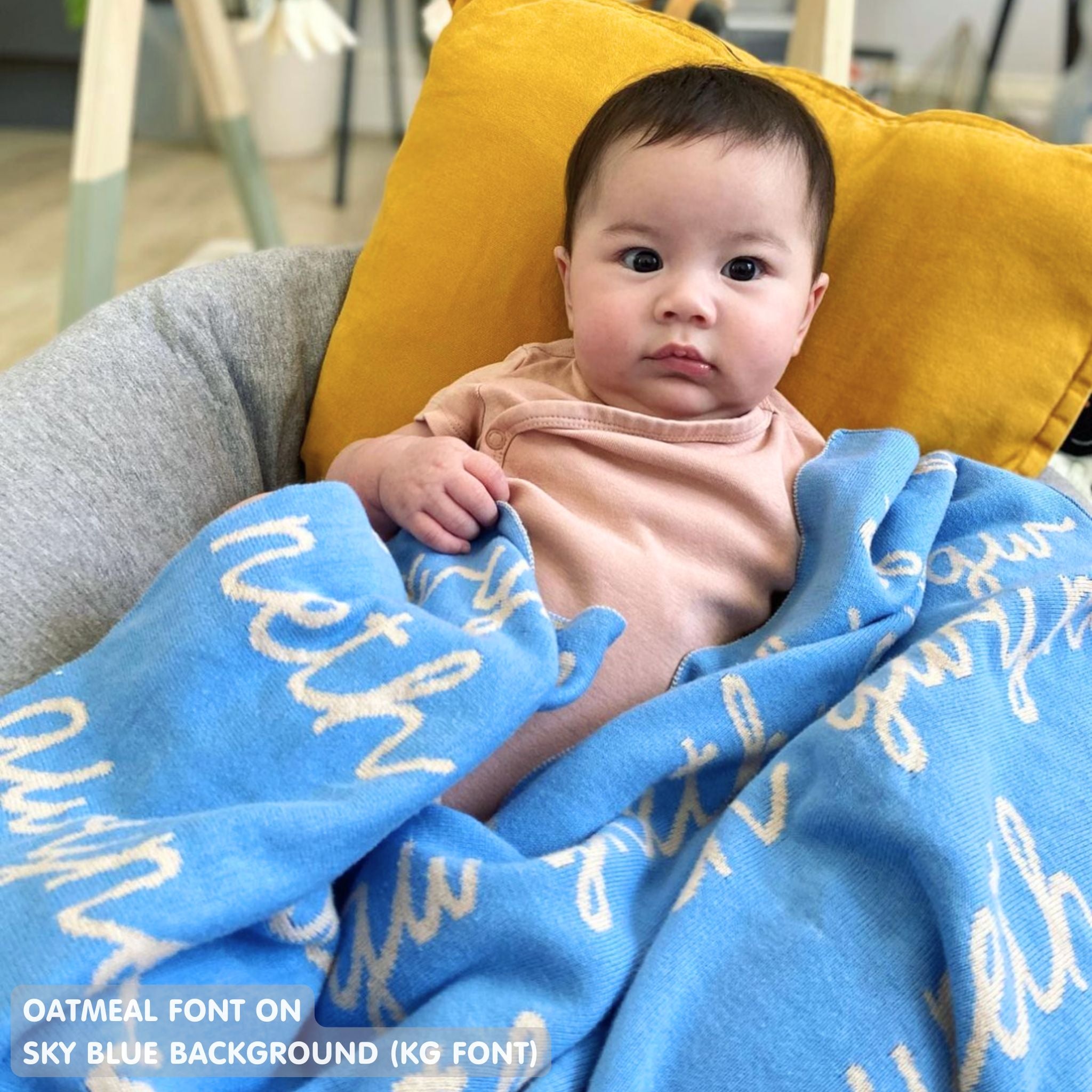 TinyBitz personalized knitted blanket in sky blue background, customized with baby's name and made from 100% cotton.
