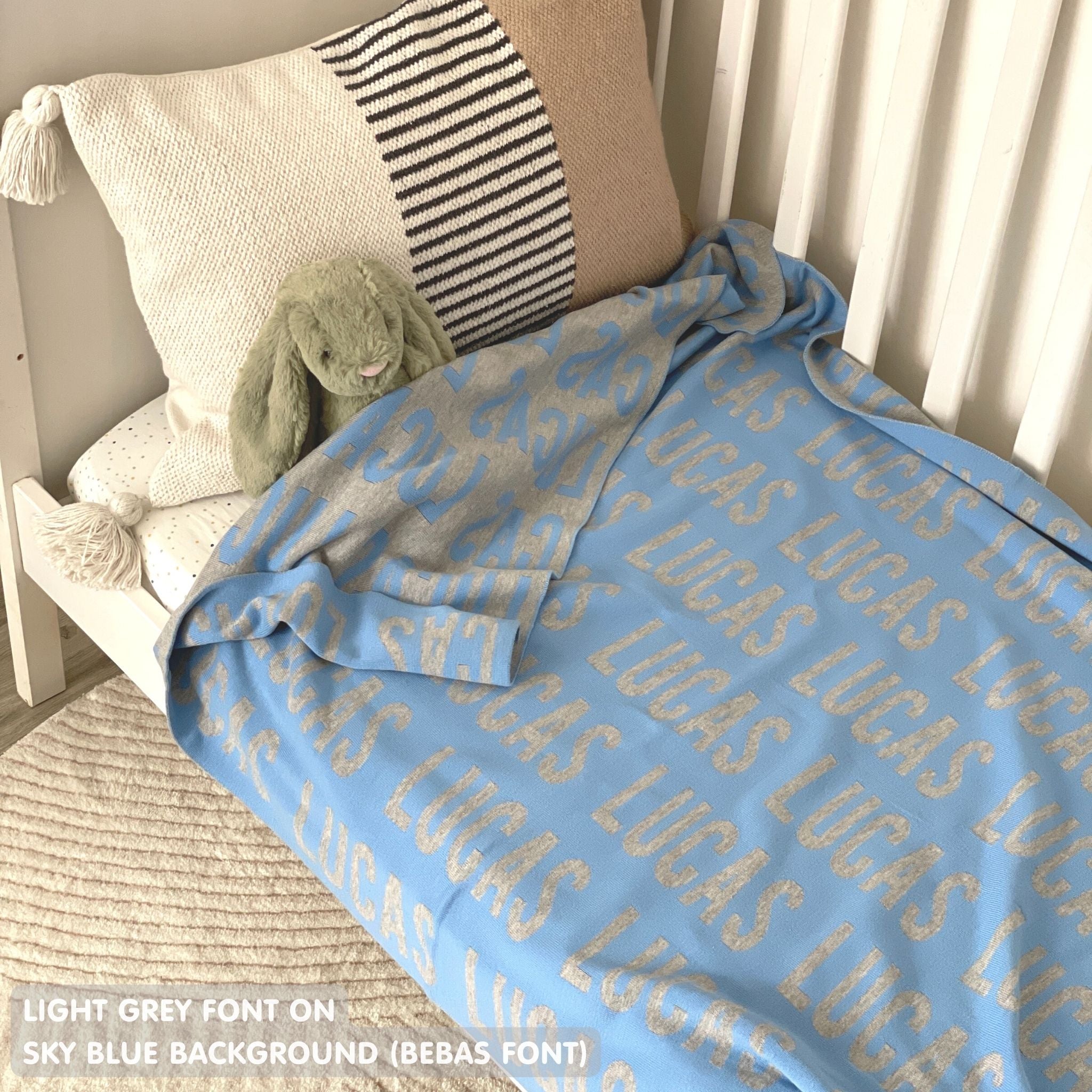 Cotton baby blanket with baby's name knitted in sky blue and light grey, made by TinyBitz.