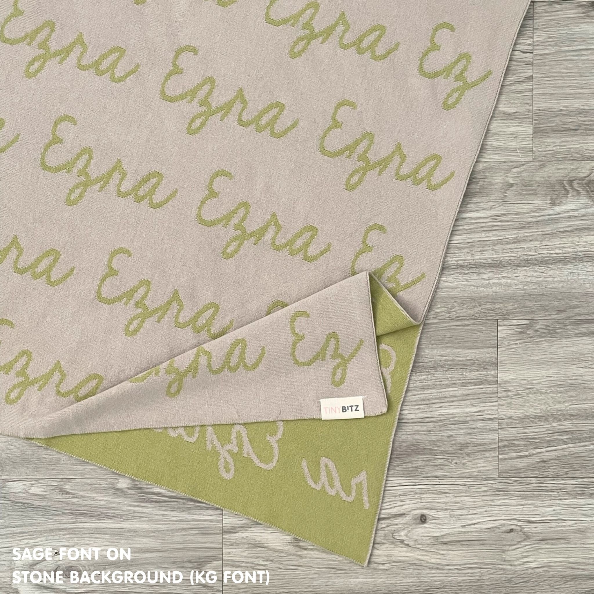 Customisable blanket with adult's name knitted in stone and sage, personalized by TinyBitz.