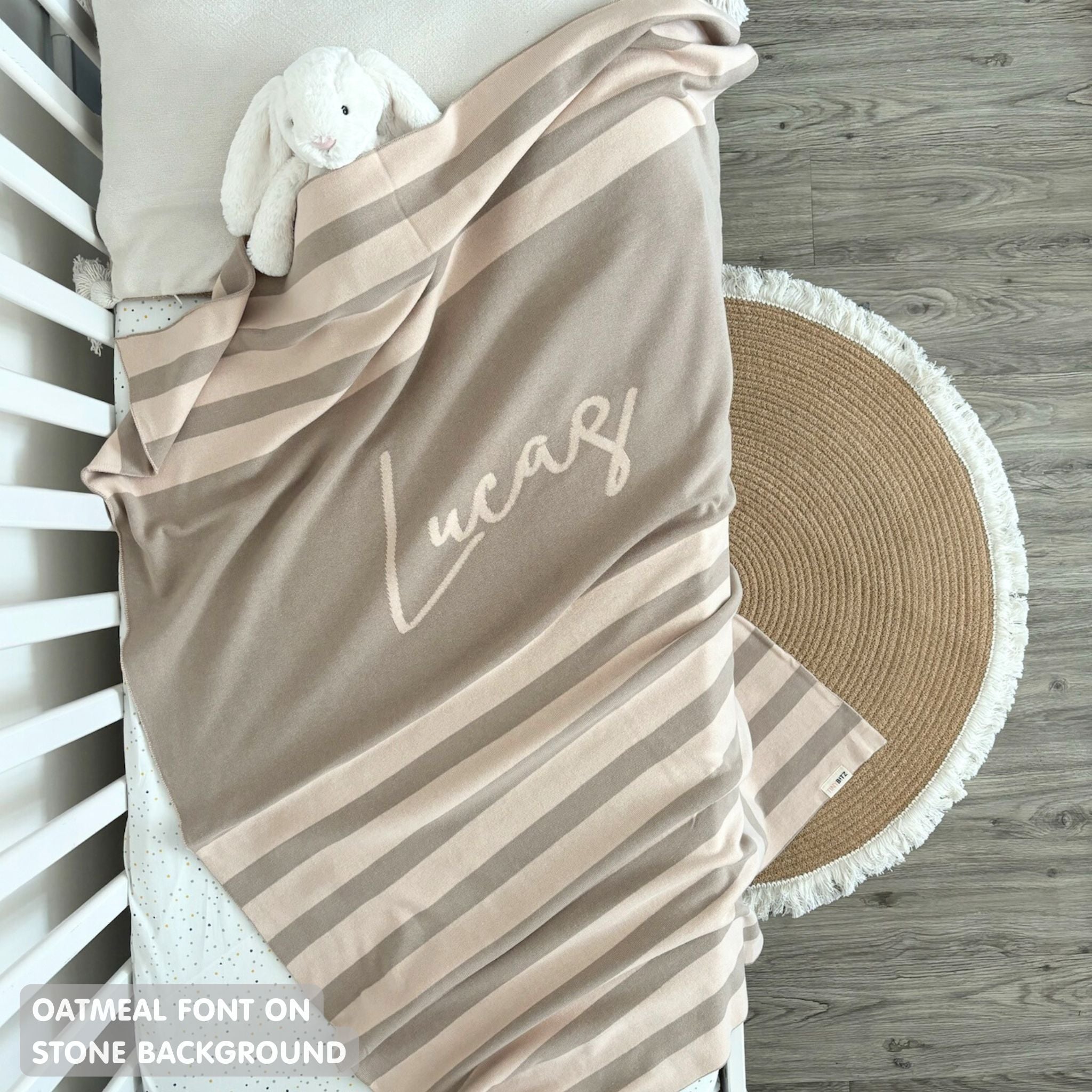 Cotton baby blanket with baby's name knitted in stone and oatmeal with a stripes pattern, made by TinyBitz.