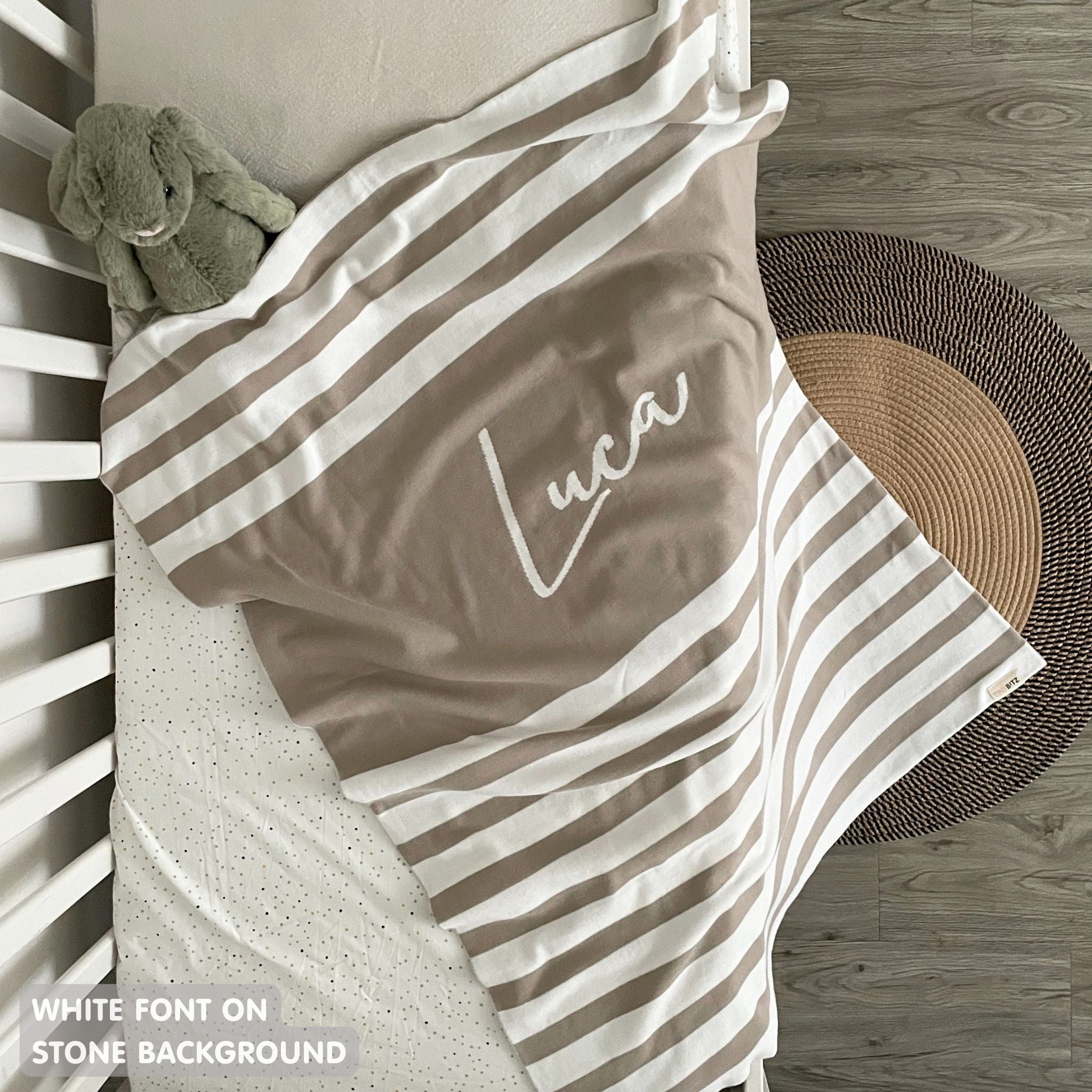 Baby blanket knitted from cotton personalized with baby's name in stone and white with a stripes pattern, made by TinyBitz.