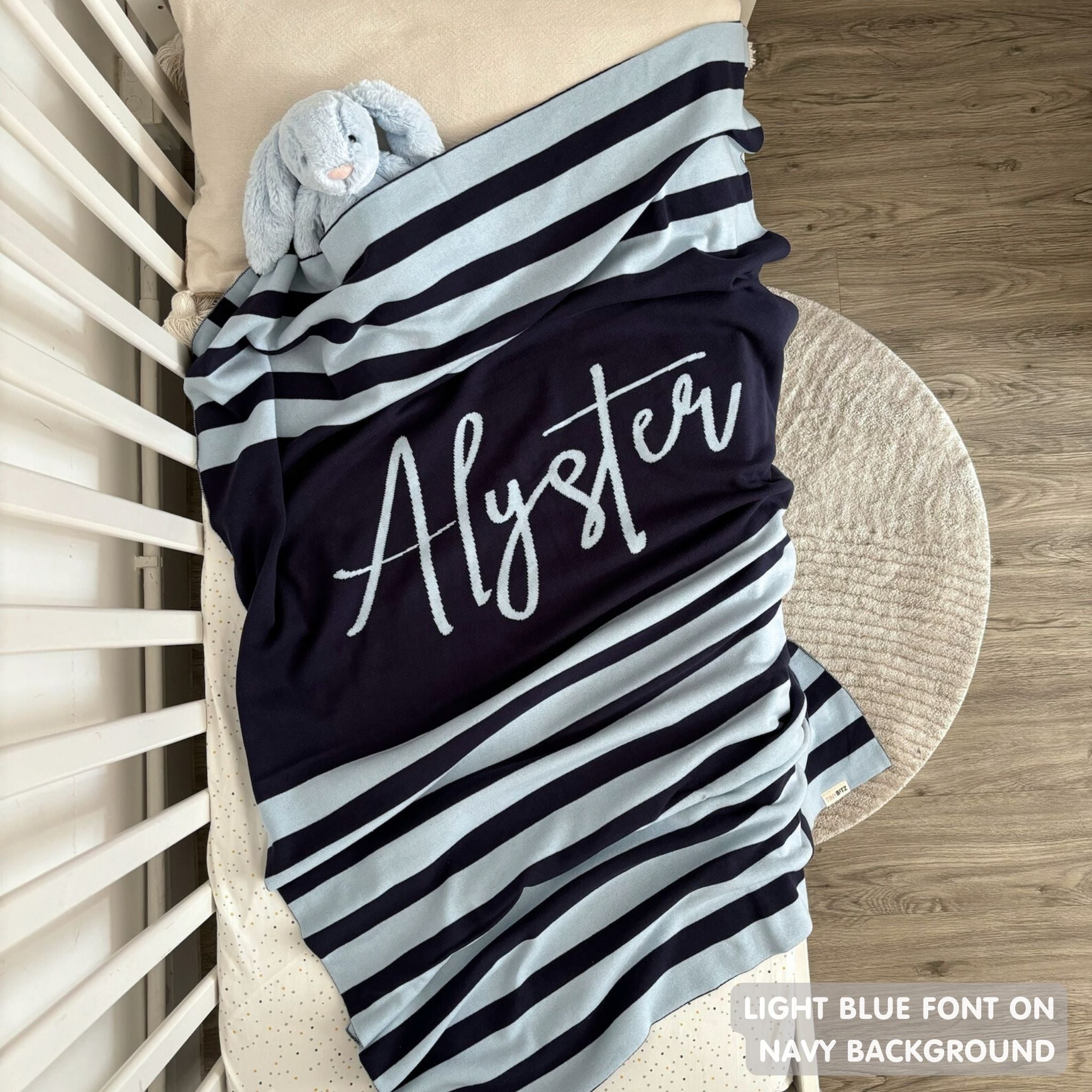 Knitted baby blanket in navy and light blue with a stripes pattern, customised with baby's name, made by TinyBitz.