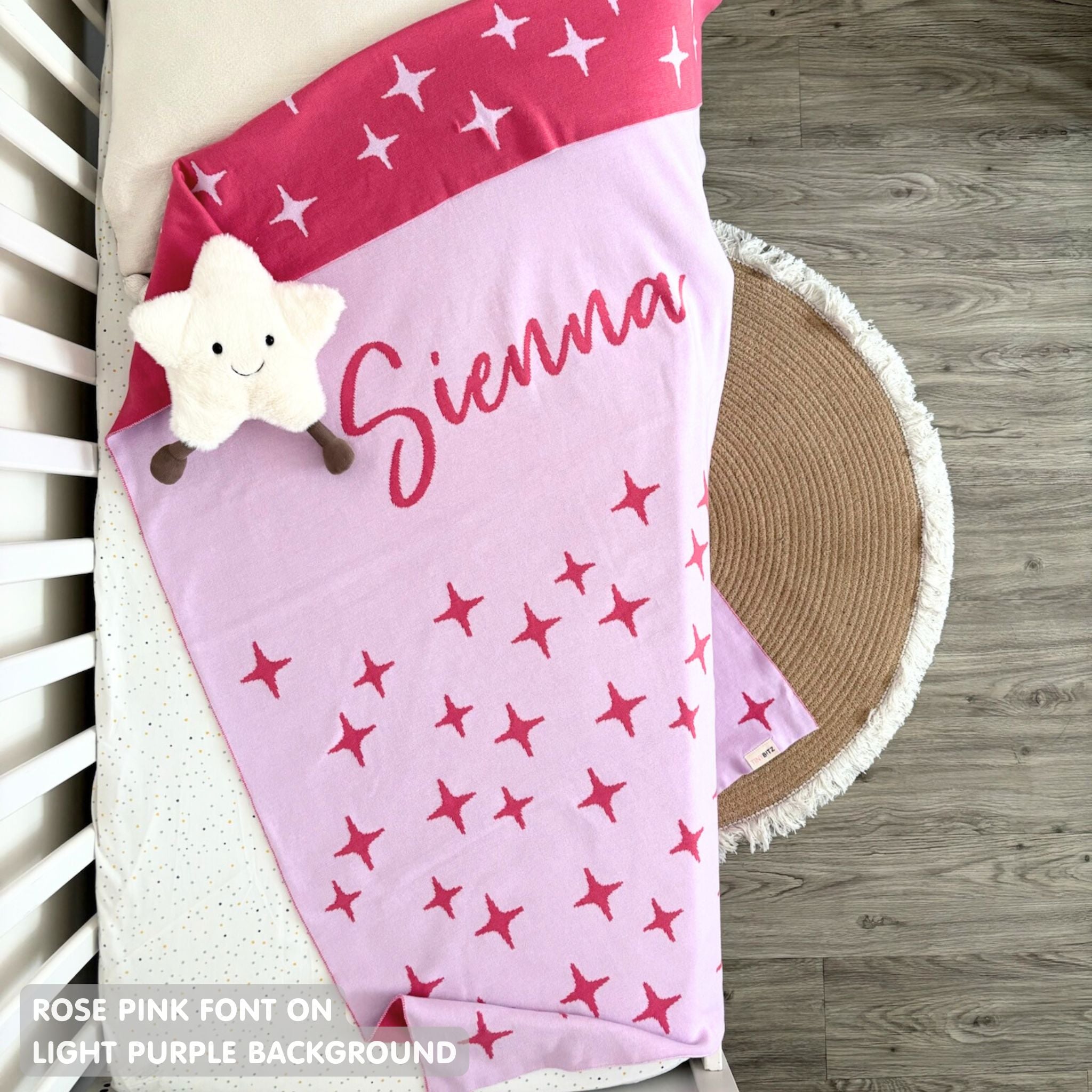 Knitted baby blanket in light purple and rose pink with a twinkles pattern, customised with baby's name, made by TinyBitz.