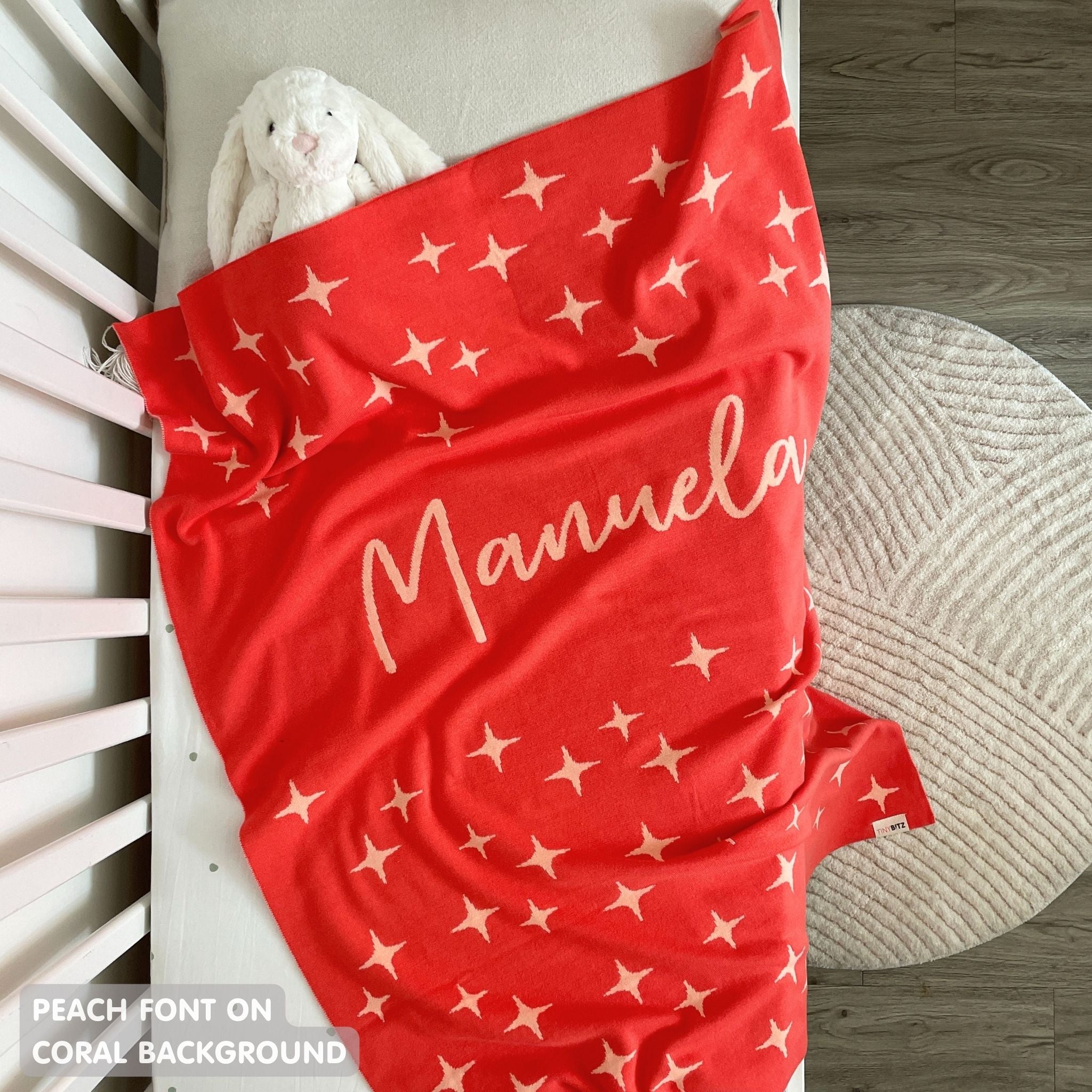 TinyBitz knitted name blanket in coral and peach with a twinkles pattern, a lovely touch to decorate your baby's room!