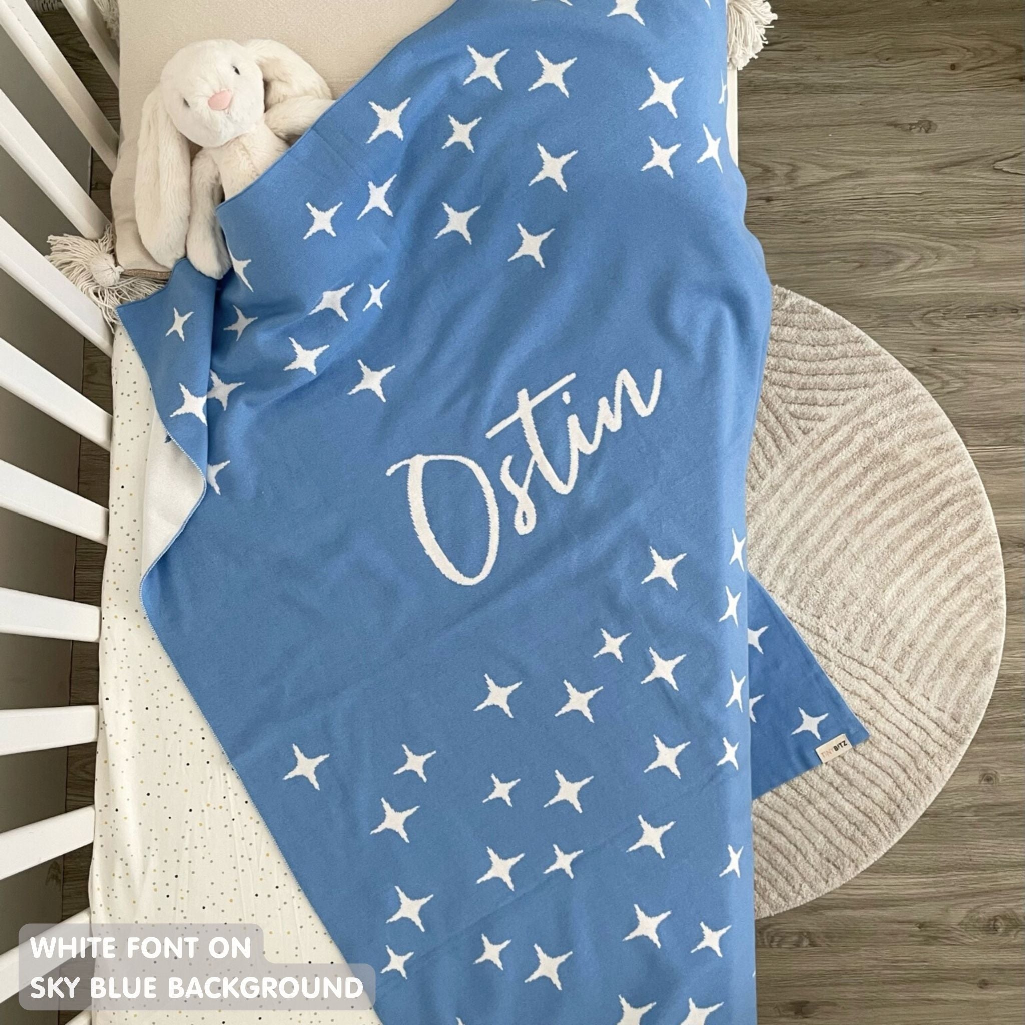TinyBitz custom knitted blanket with baby's name on sky blue background with a twinkles pattern, best gift to welcome a newborn baby.