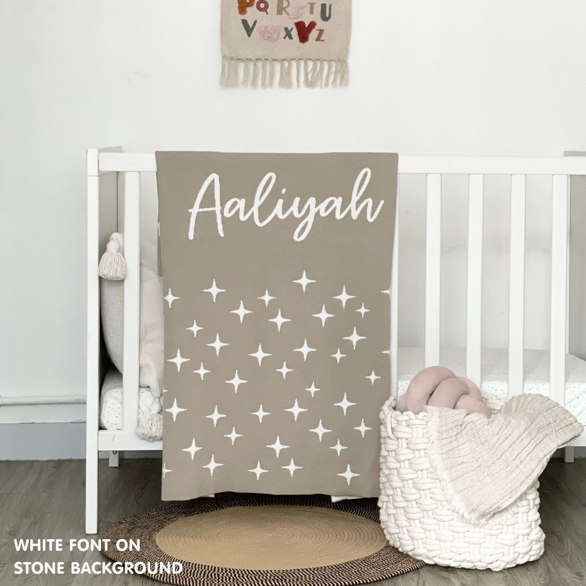 Cotton baby blanket with baby's name knitted in stone and white with a twinkles pattern, made by TinyBitz.