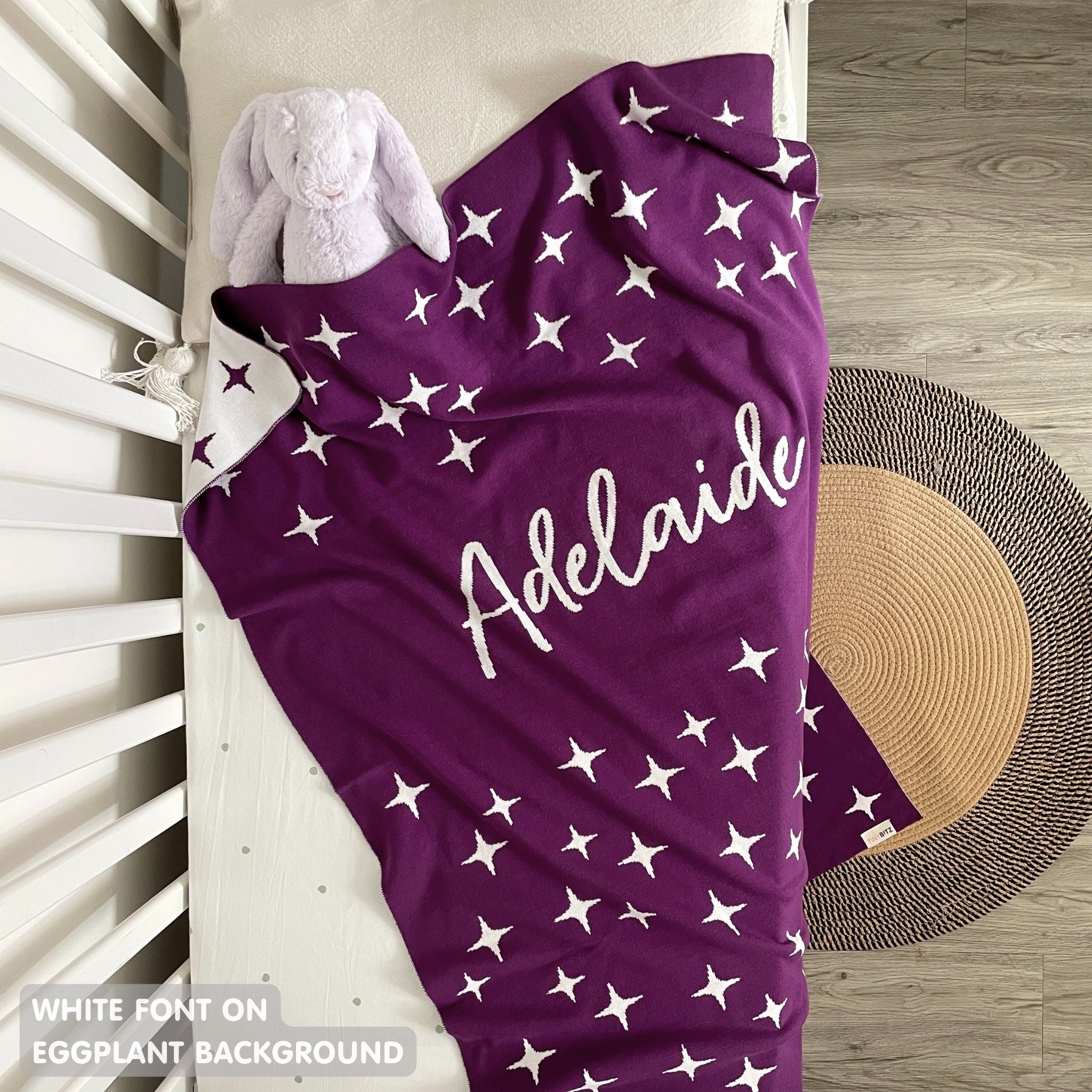 TinyBitz custom knitted blanket with baby's name on eggplant background with a twinkles pattern, best gift to welcome a newborn baby.